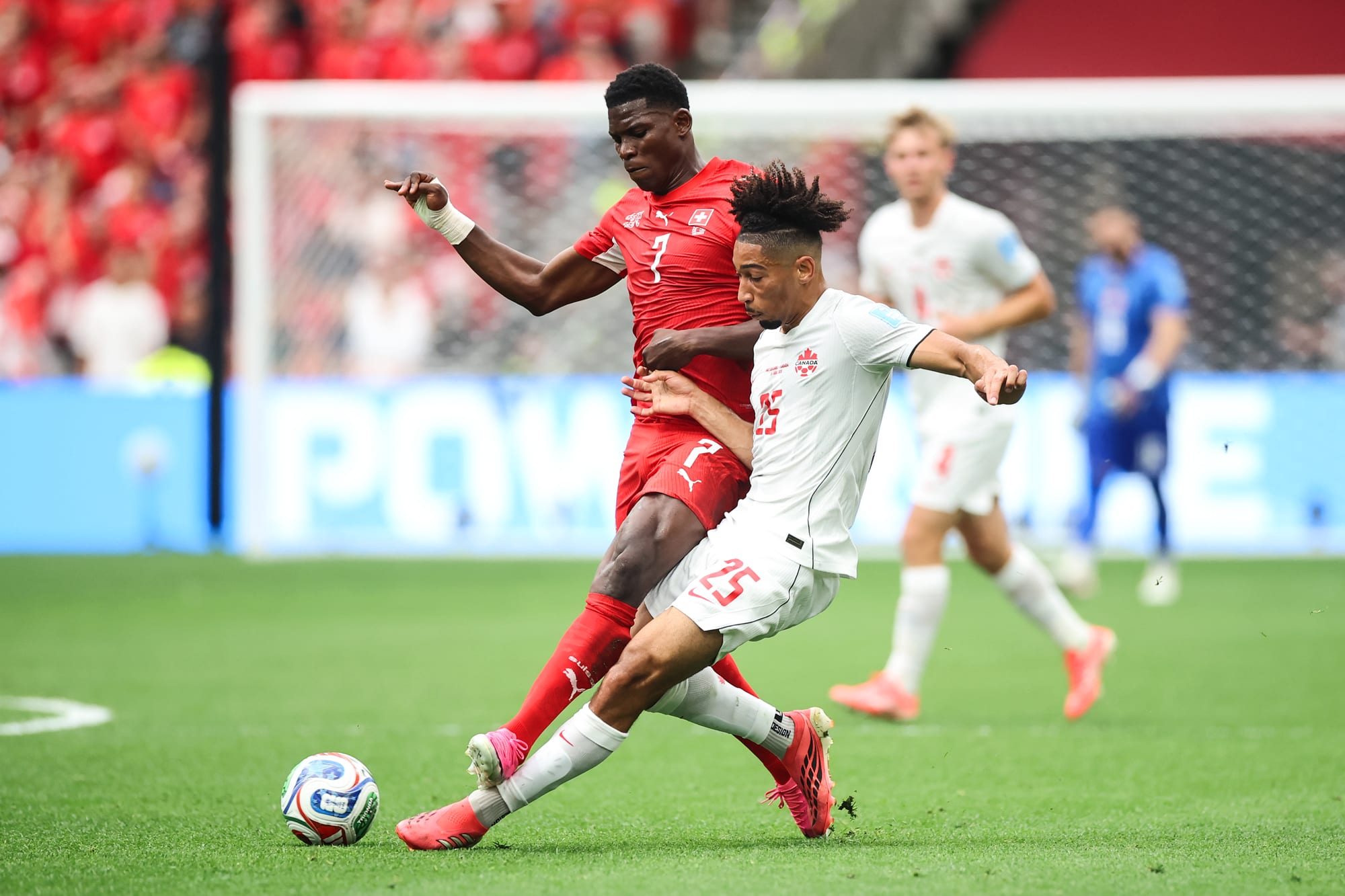 Breel Embolo #7 of Switzerland and Nathan Saliba #25 of Canada compete for the ball