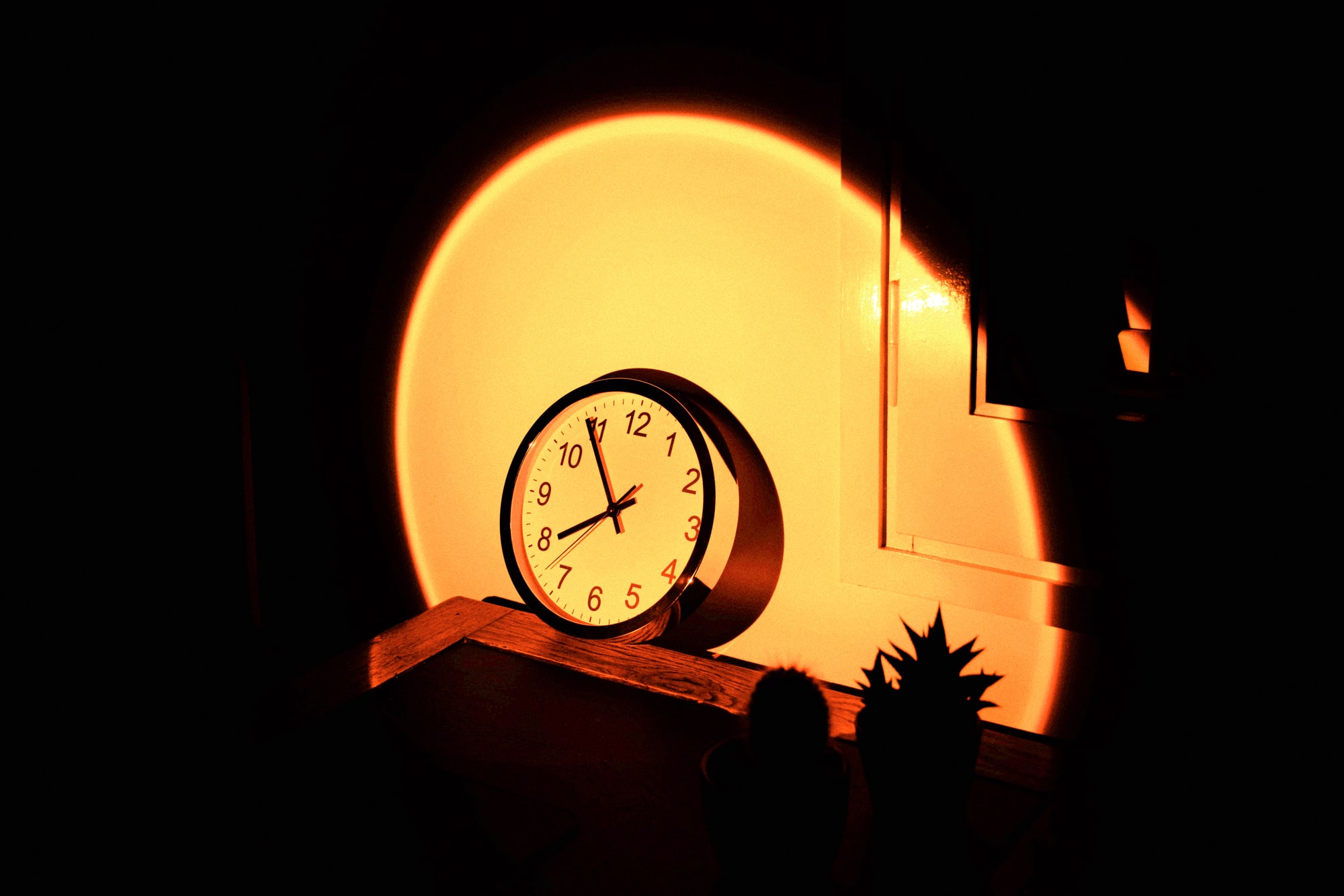 Wall clock in office desk with big sunset sun light effect.
