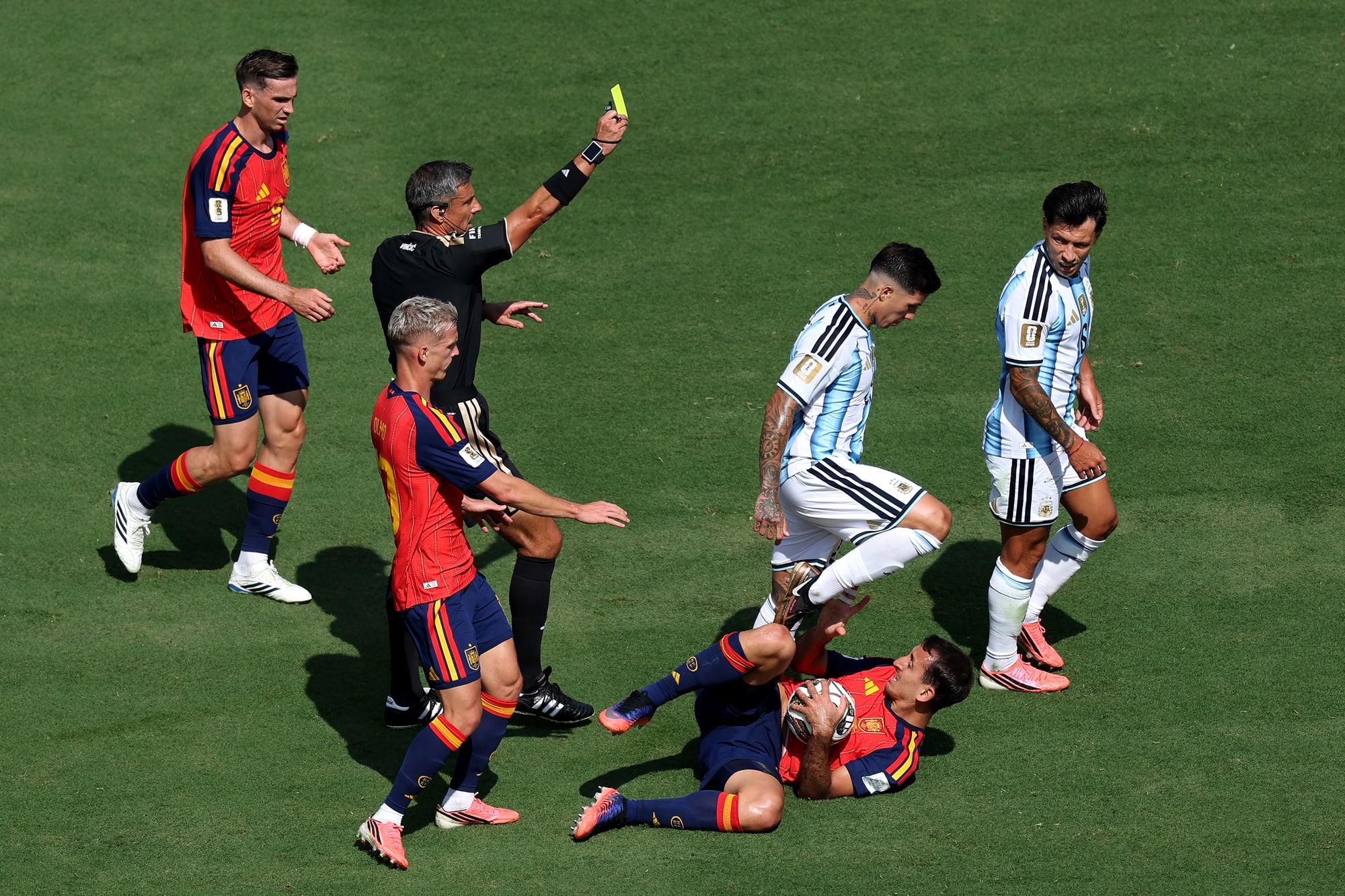 Referee Slavko Vincic shows a yellow card to Lisandro Martinez on the field