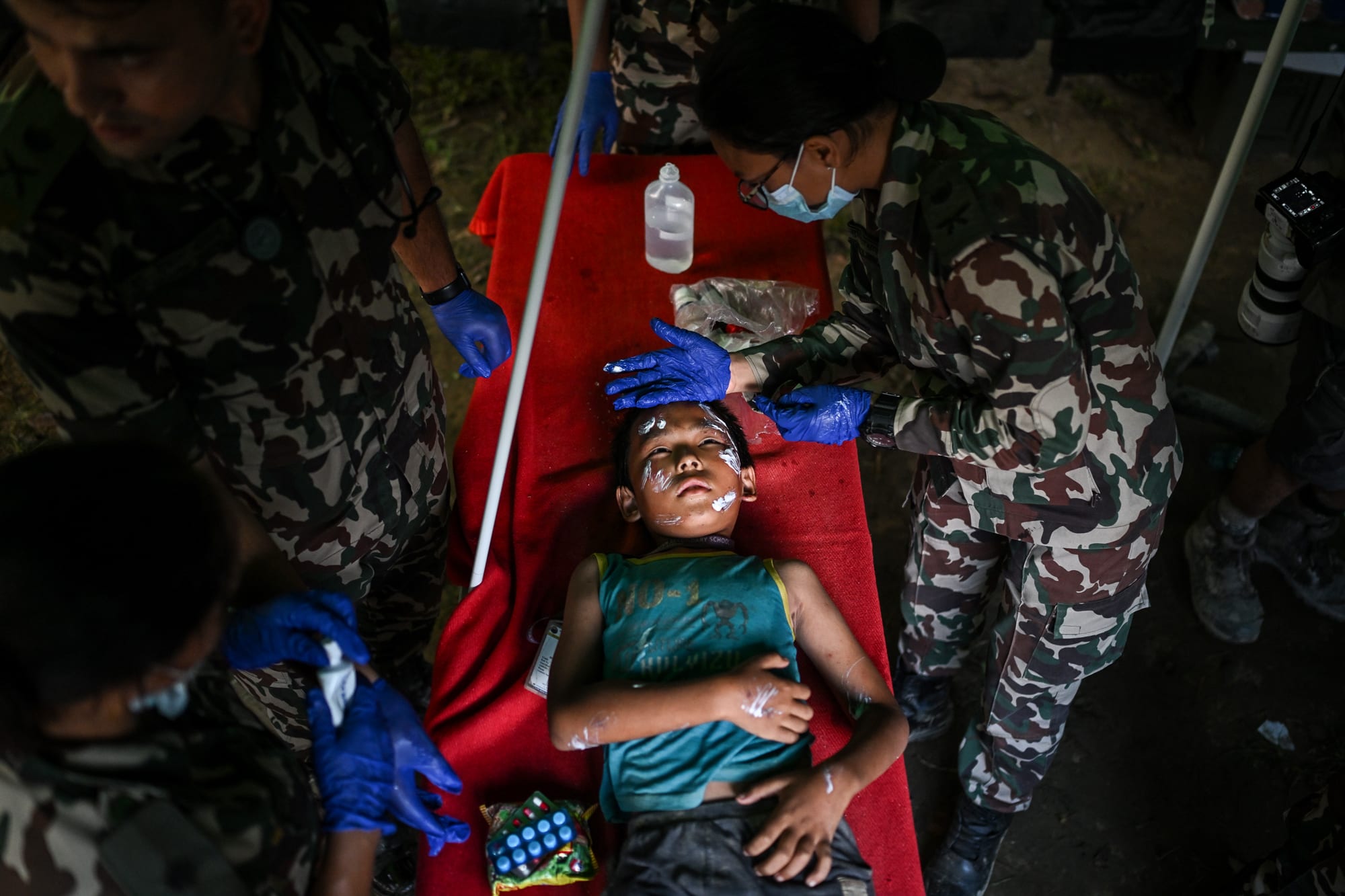 Rescue personnel provide medical treatment to a child laying on a table