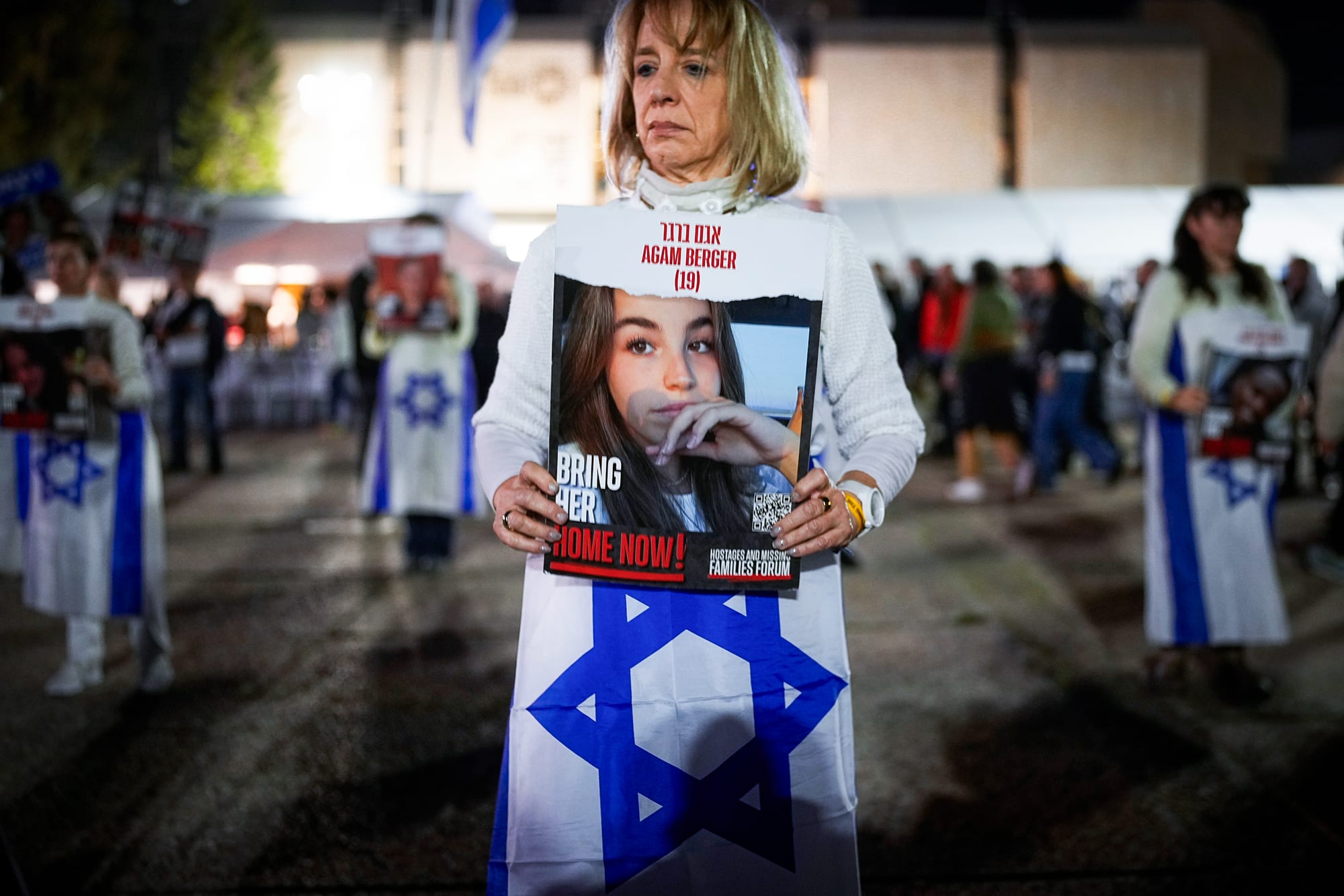 A woman holds a poster of a missing Israeli hostage