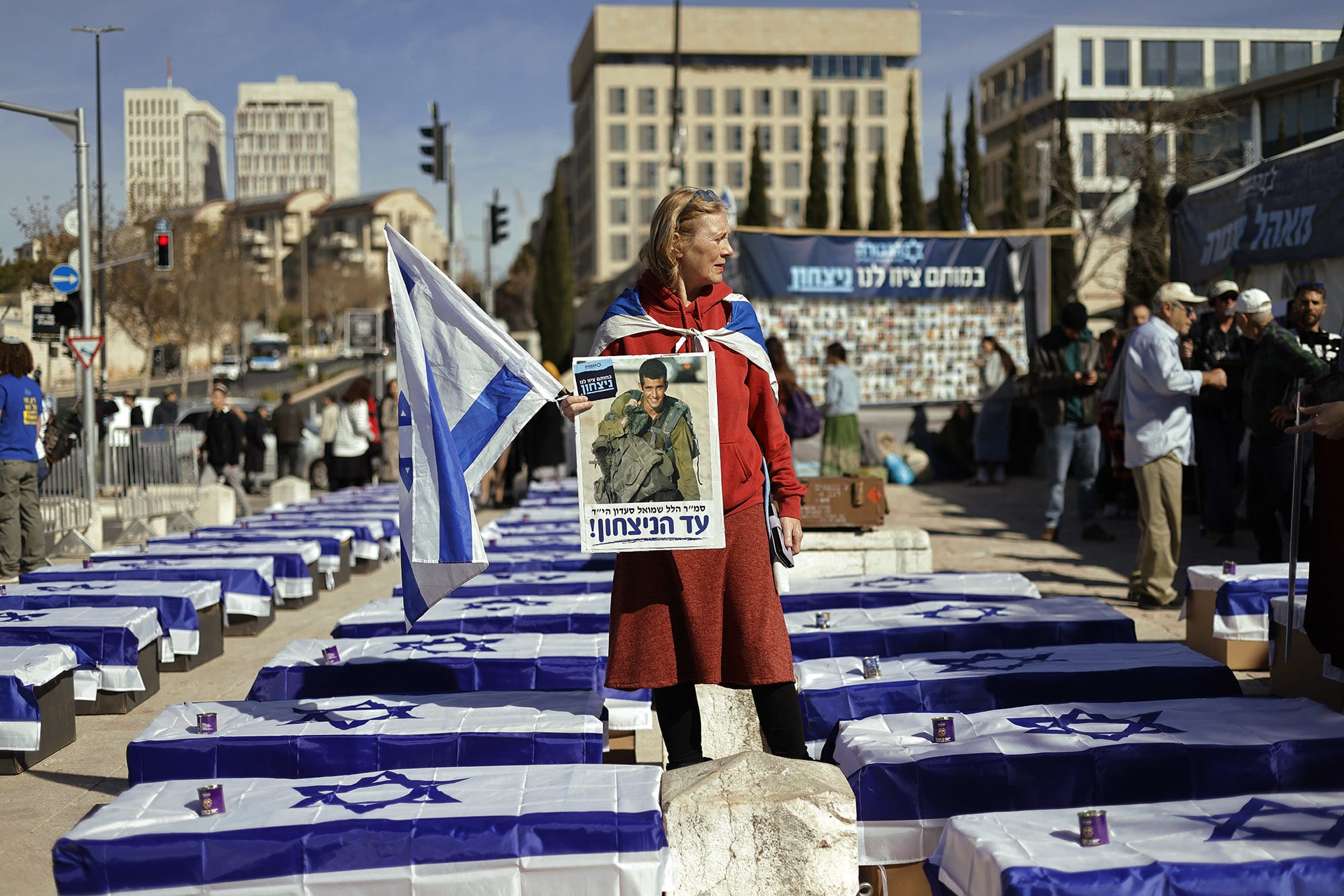 A demonstrator stands amid mock coffins draped in Israeli flags to protest the ceasefire with Hamas outside the Supreme Court in Jerusalem on Jan. 16, 2025.