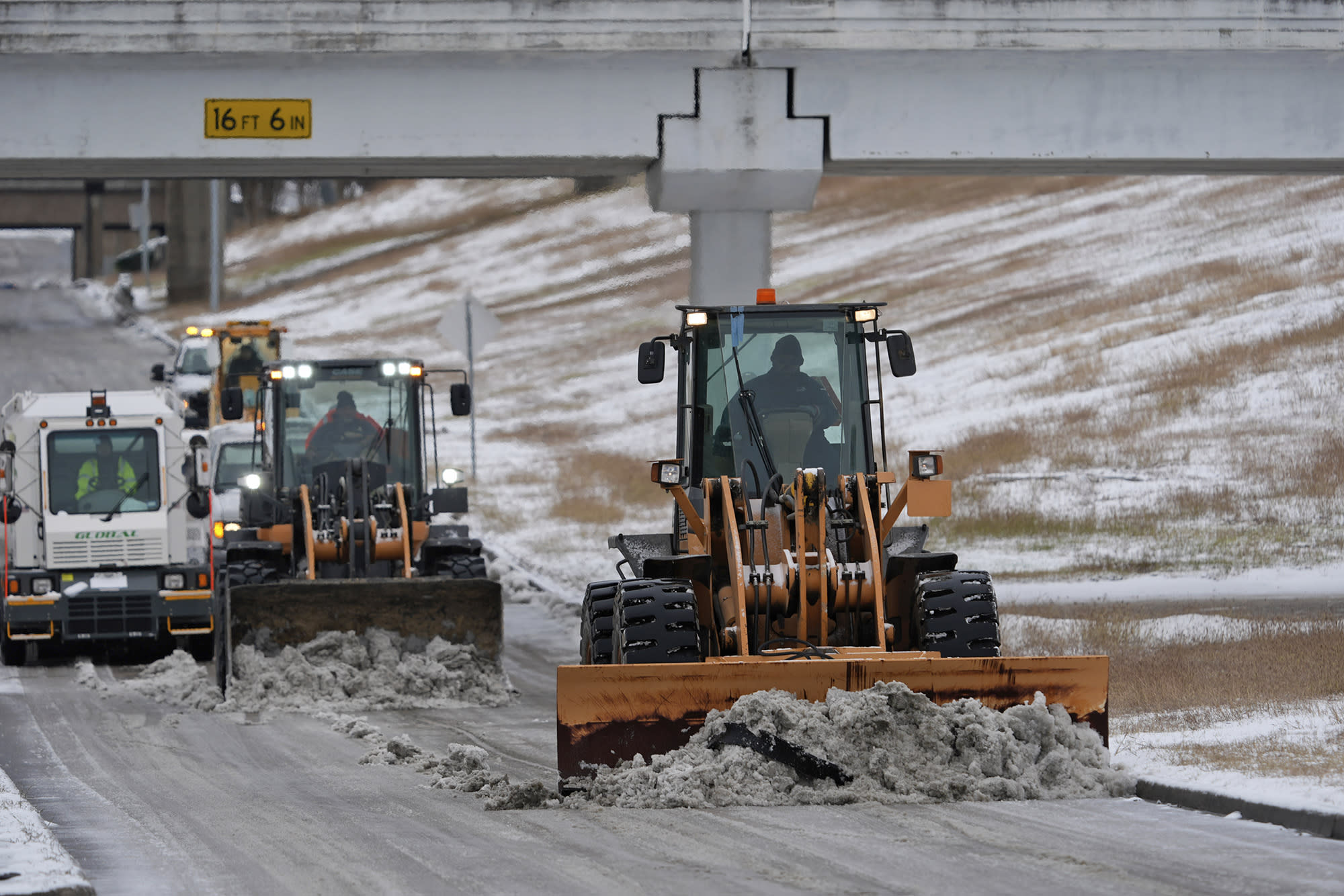 Plows clear snow at the closed George Bush Intercontinental Airport Tuesday, Jan. 21, 2025, in Houston. 