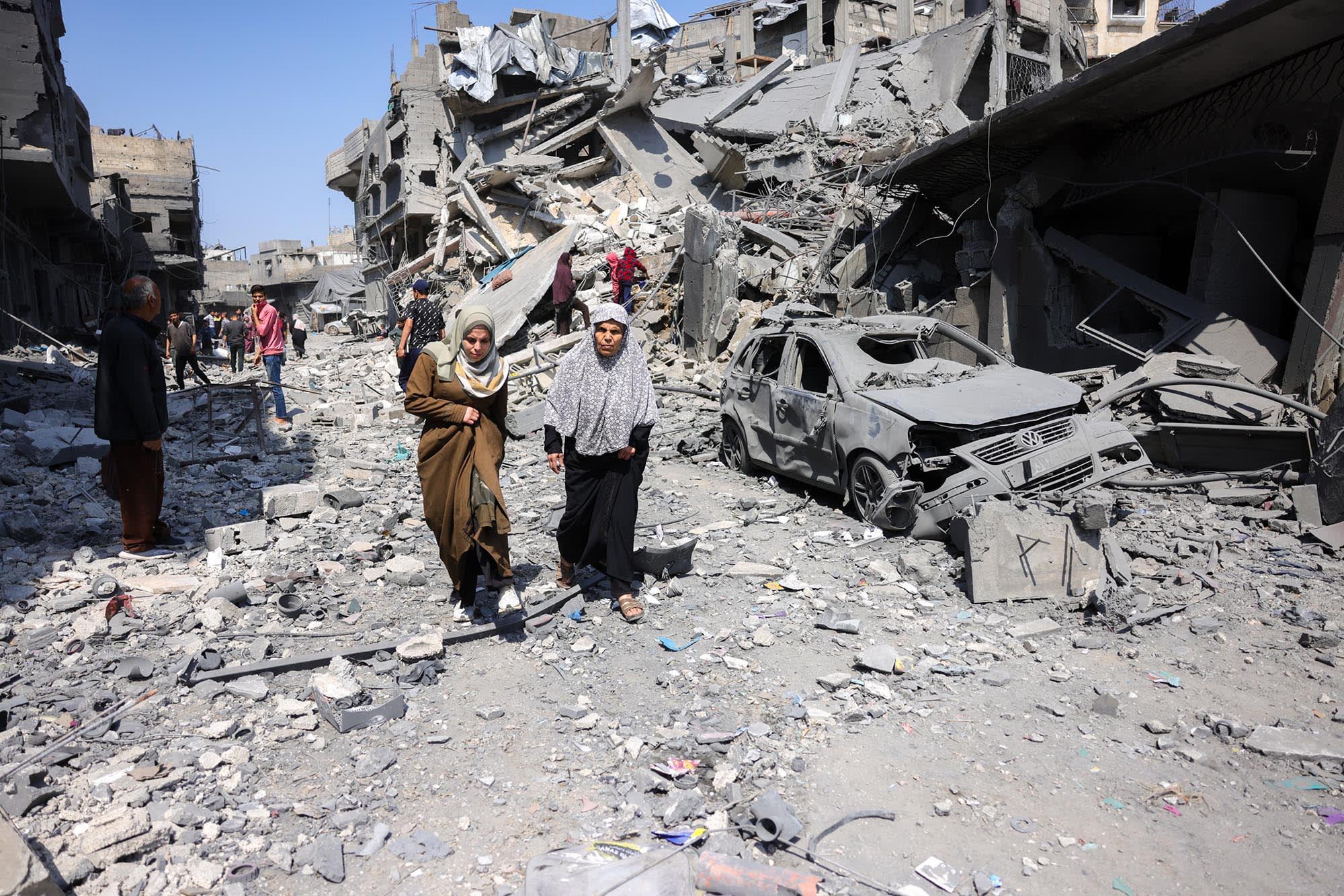 People walk amid the rubble of a building destroyed in an overnight Israeli strike in Jabaliya, Gaza, on March 18, 2025. 