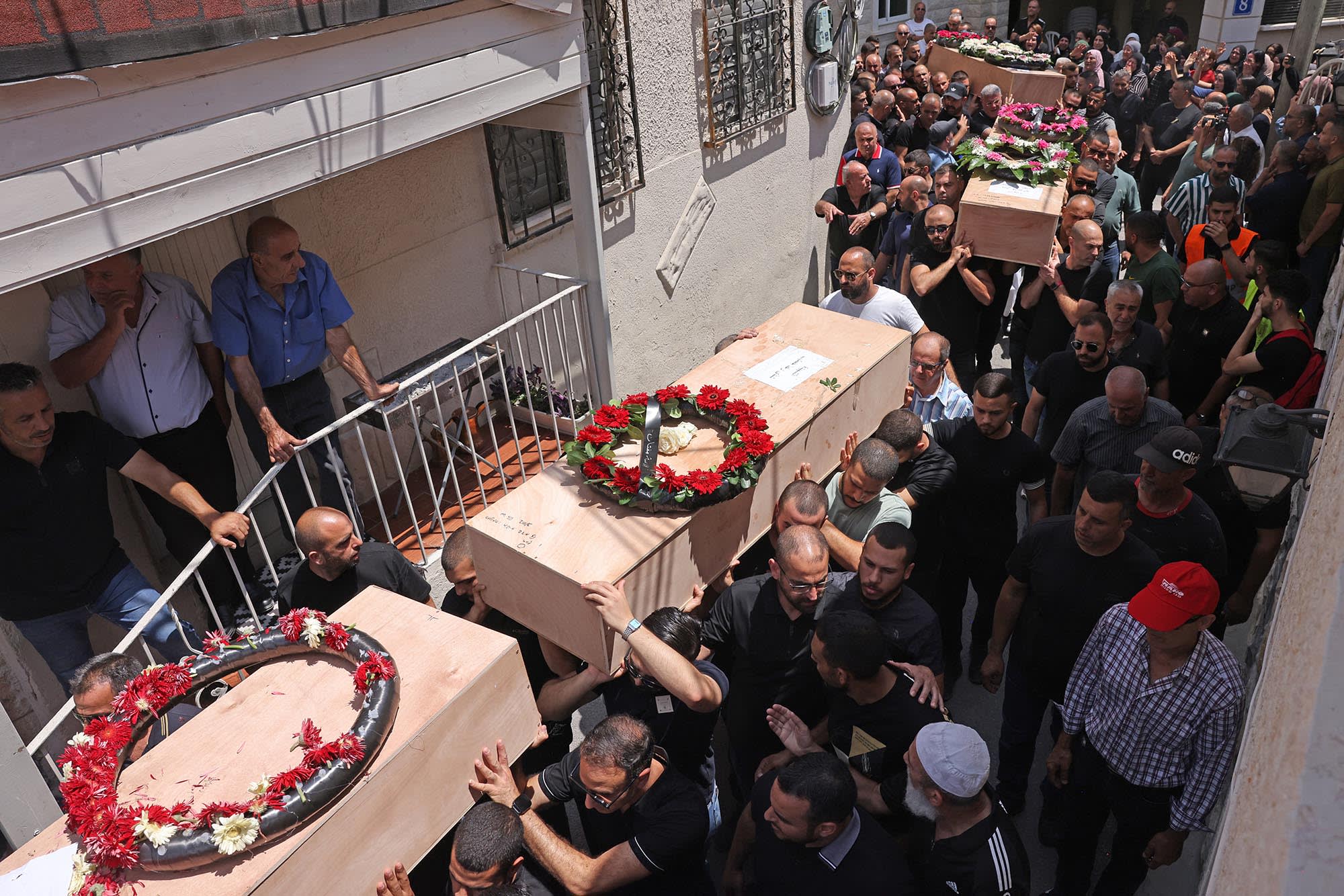 Mourners carry the caskets of victims of an Iranian missile attack which destroyed a three-storey building in the northern Arab-Israeli city of Tamra