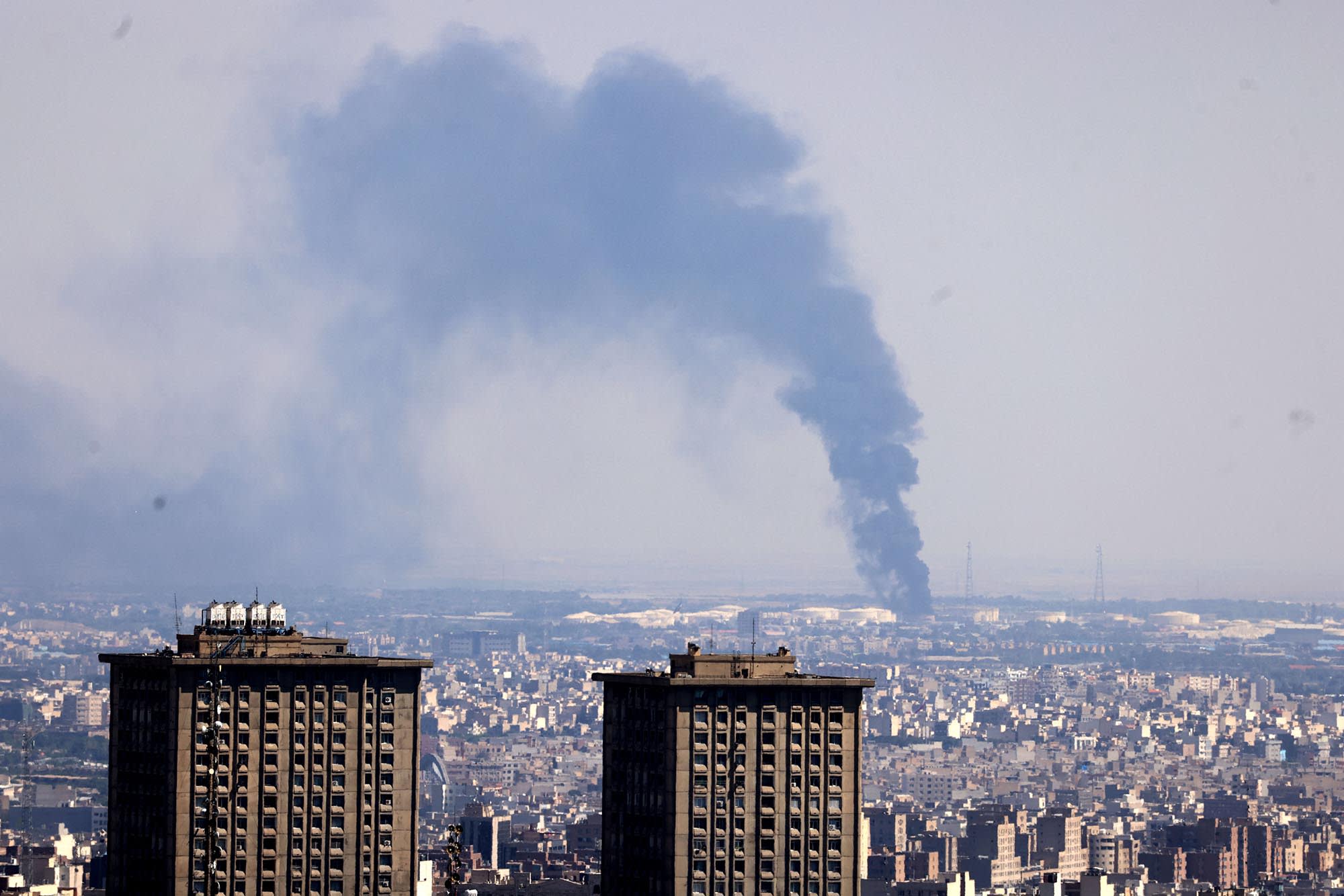 Smoke billows in the distance from an oil refinery following an Israeli strike on the Iranian capital Tehran on June 17, 2025. 