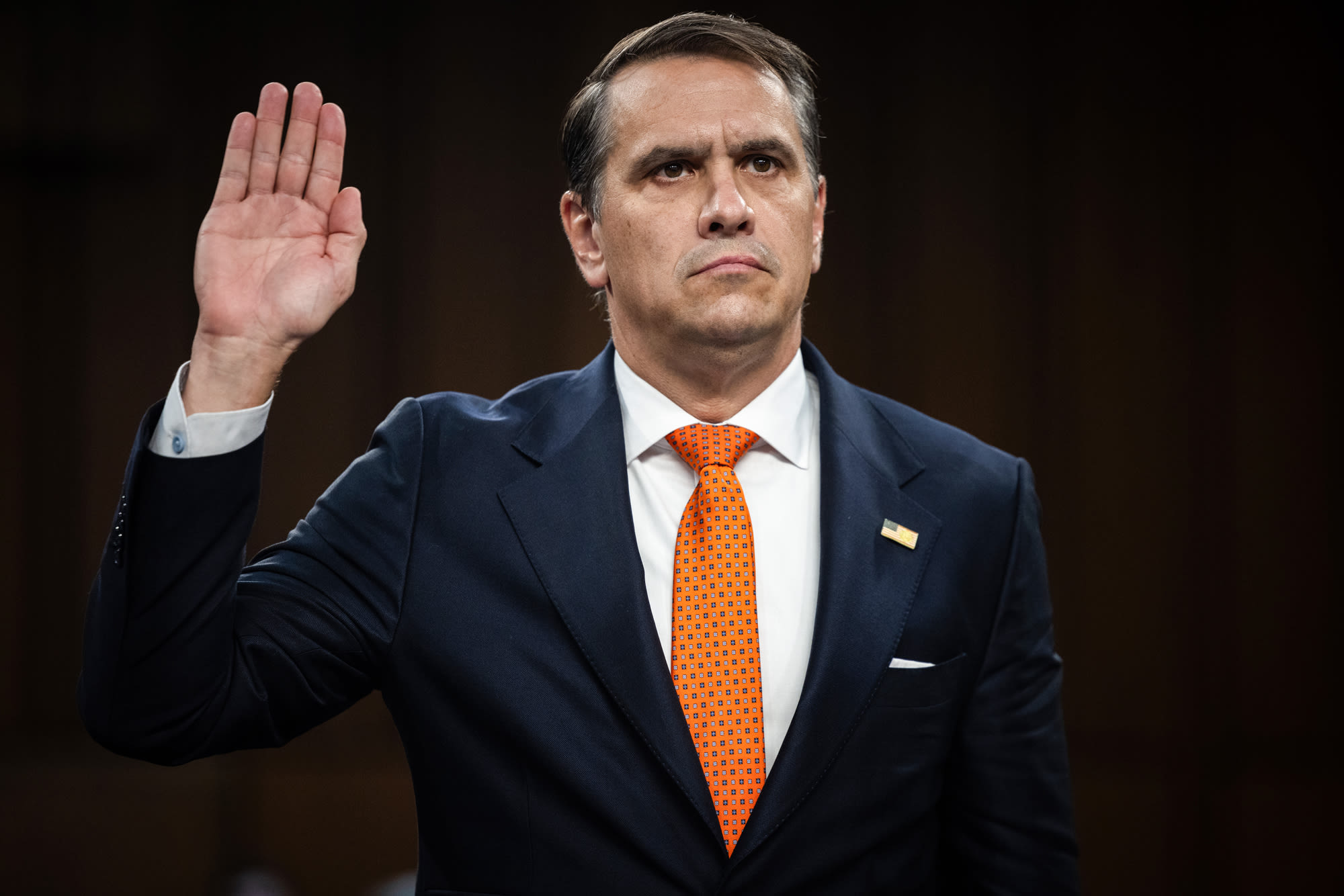 Todd Blanche raises a hand while standing