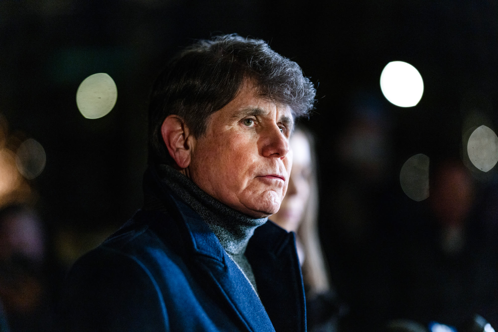 Rod Blagojevich stands outside at night