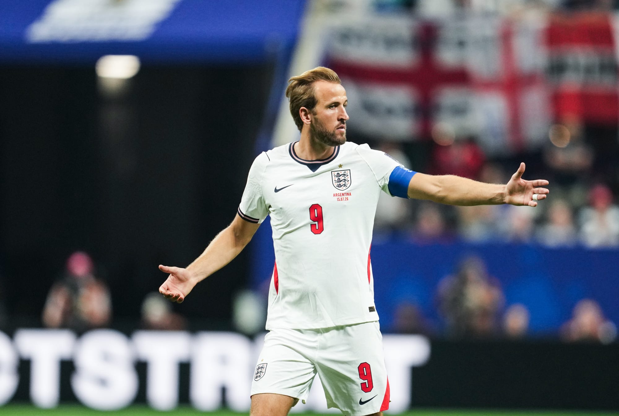 Harry Kane walks on the field with his arms outstretched