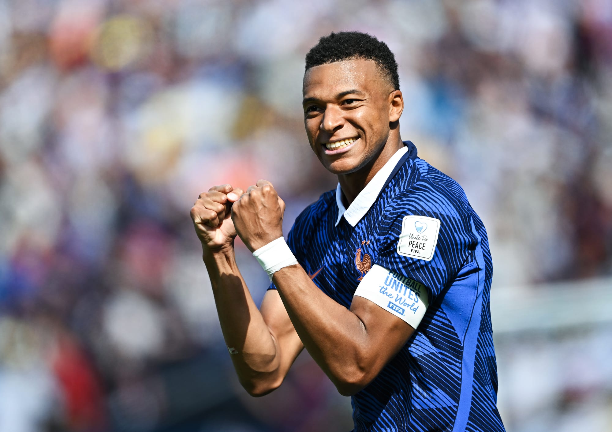 Mbappe curls his fists in celebration on the field