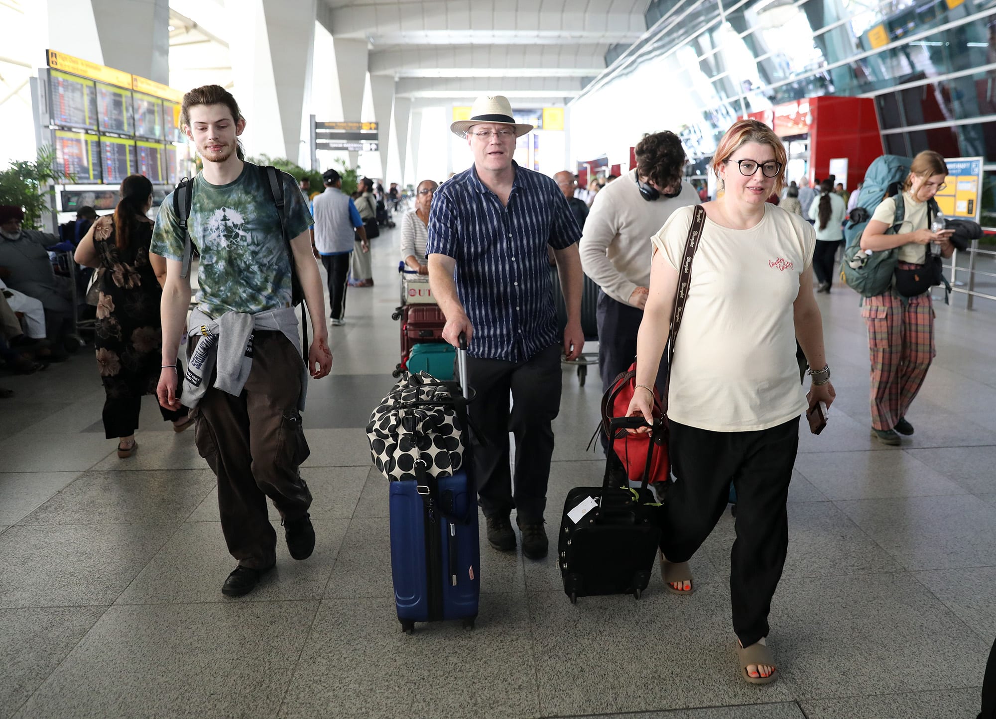 Passengers leave Indira Gandhi International Airport in New Delhi after their flight scheduled for London was cancelled on March 21, 2025. 