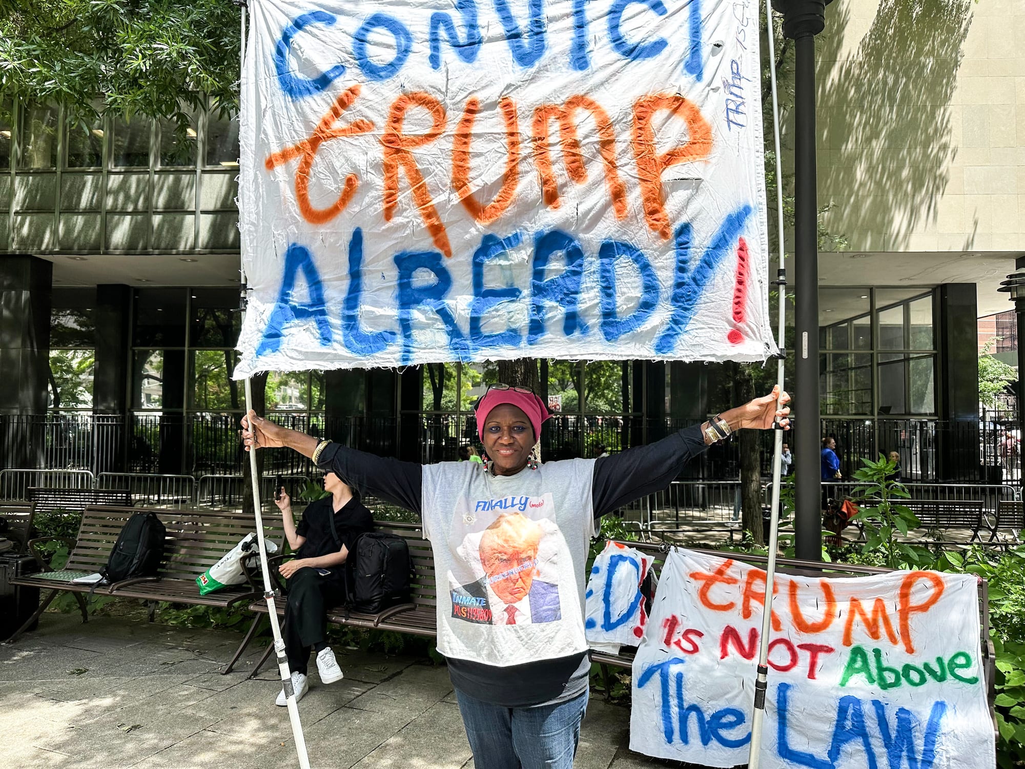 Nadine Seiler holds a sign that says "Convict Trump Already!"
