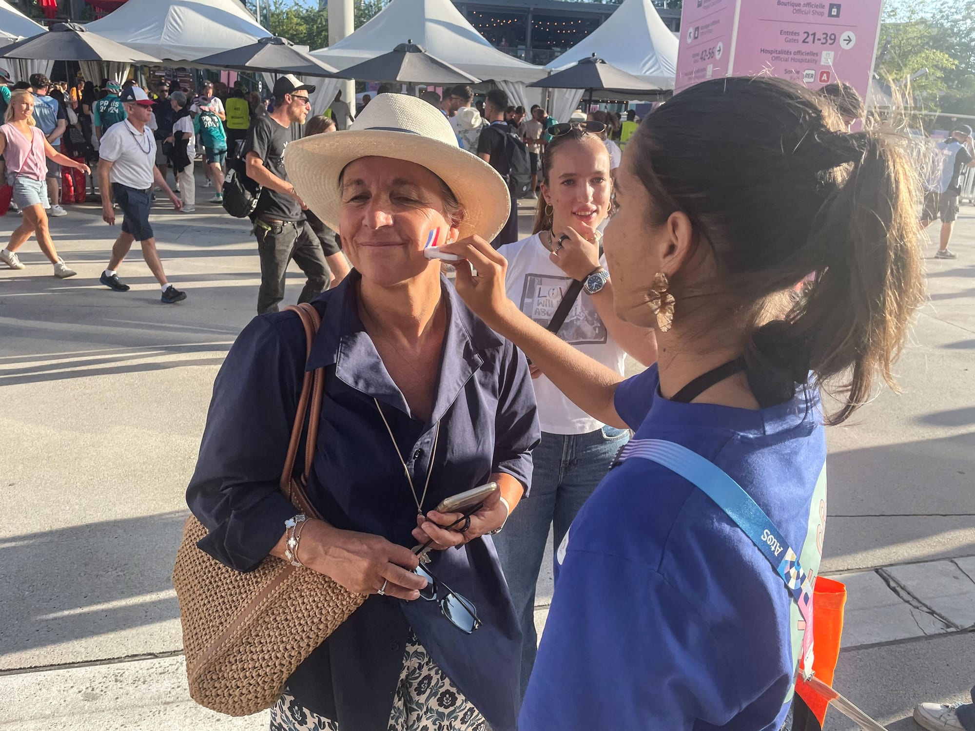 A person gets the French flag painted on their cheek