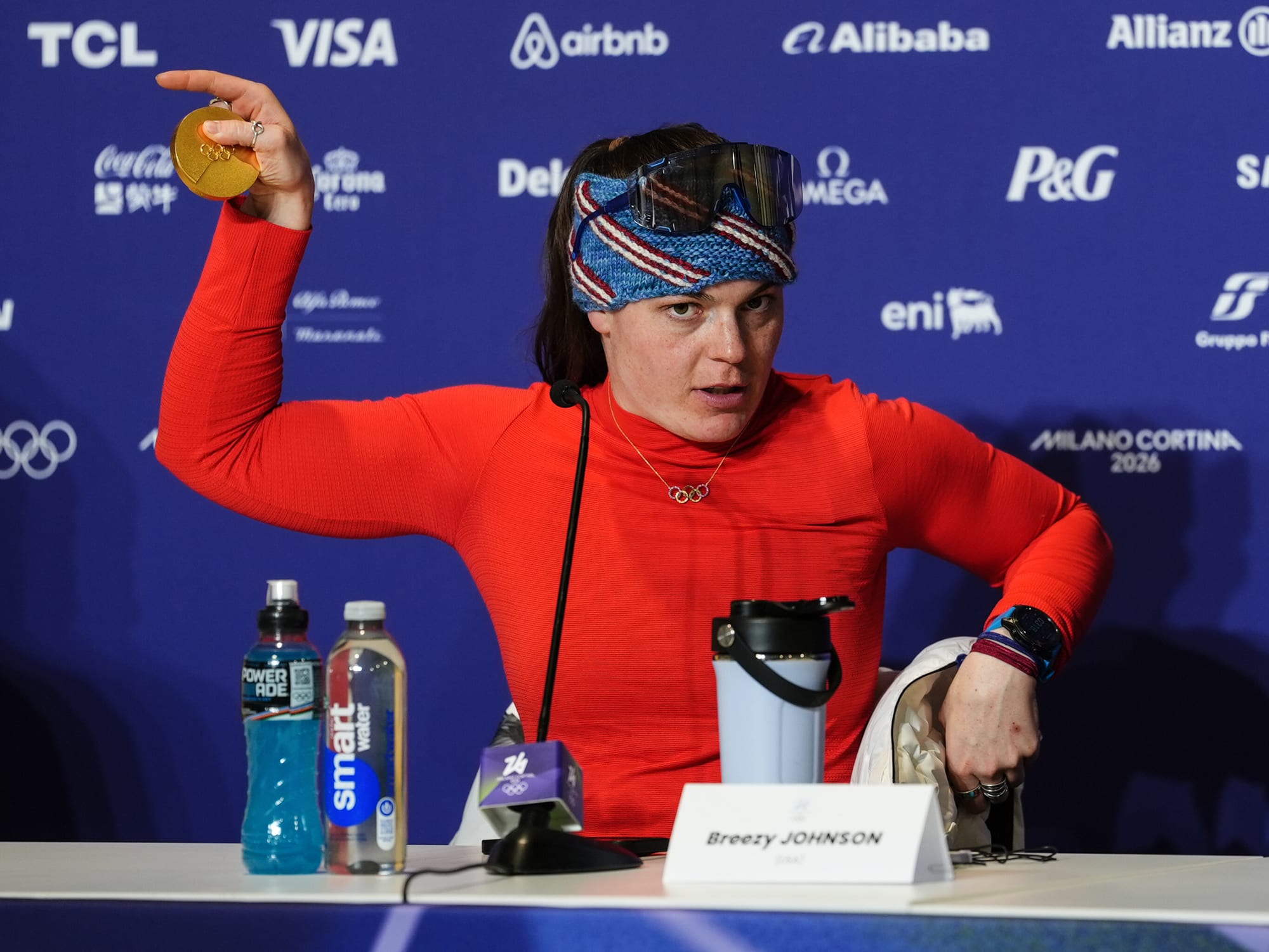 Breezy Johnson holds the gold piece of her broken medal, detached from the necklace portion