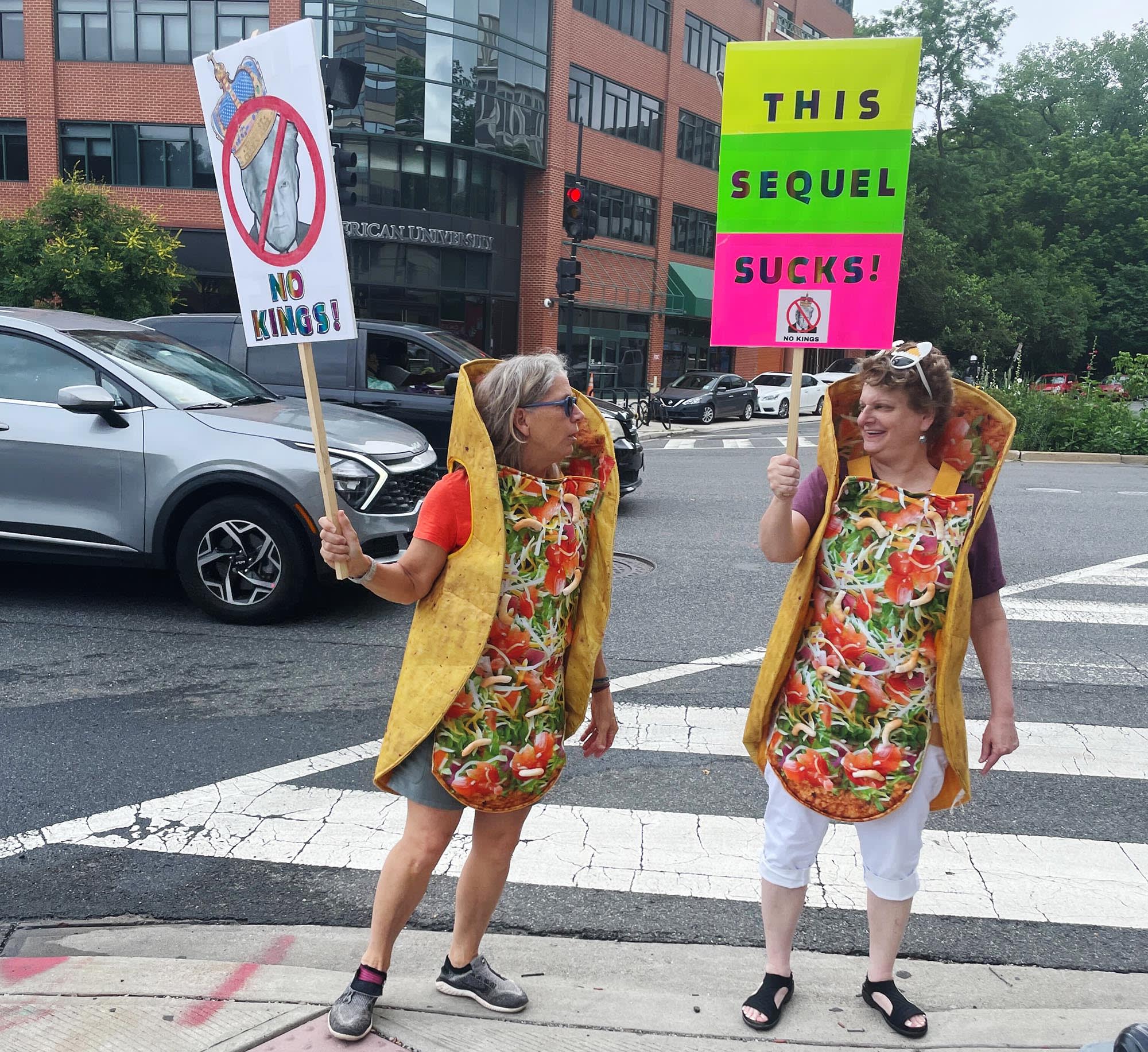 Demonstrators in taco costumes hold "No Kings" protest signs in Washington, D.C., on June 14, 2025.