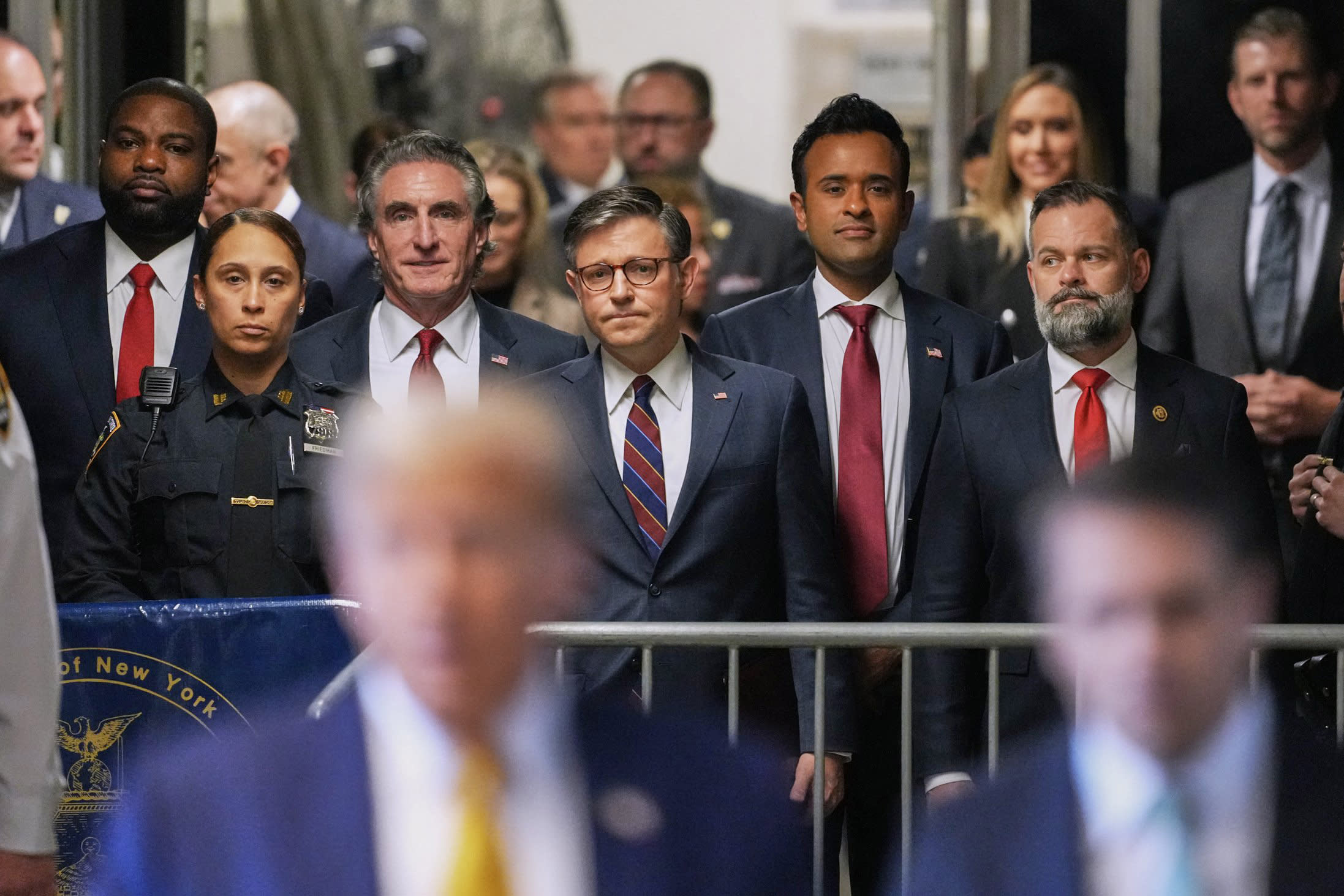Rep. Byron Donalds, R-Fla., North Dakota Governor Doug Burgum, House Speaker Mike Johnson, former presidential candidate Vivek Ramaswamy and Rep. Cory Mills, R-Fla., listen as former President Donald Trump speaks to reporters