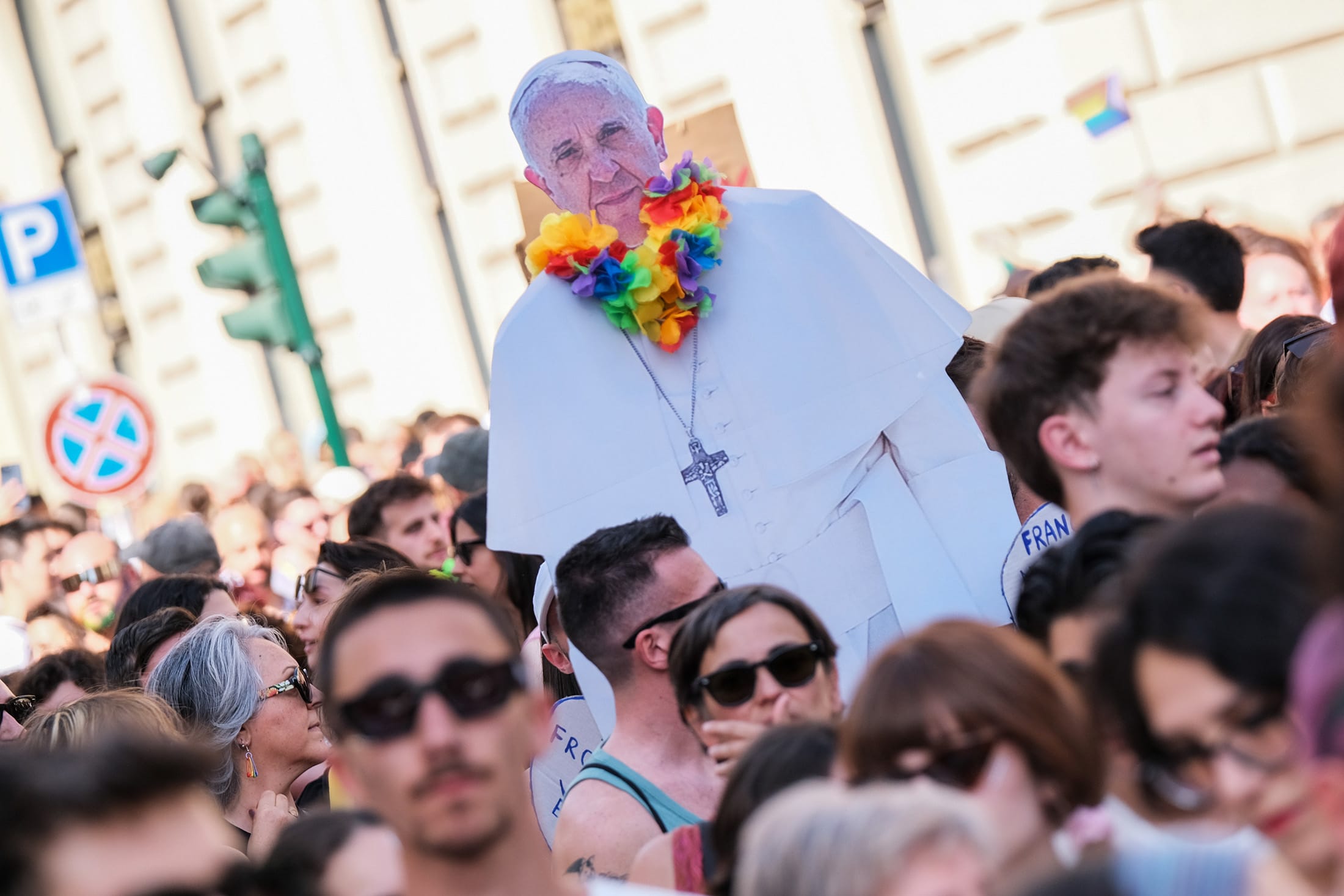A sign with a silhouette of Pope Francis wearing a rainbow