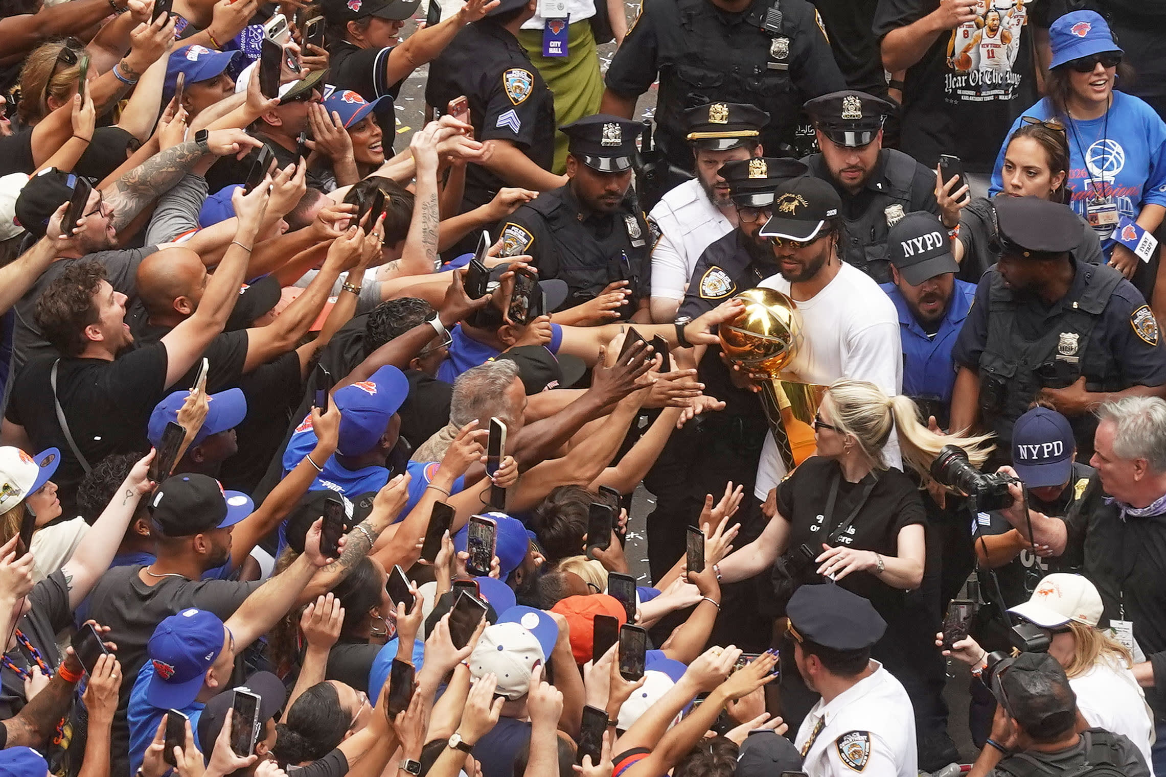 Jalen Brunson of the New York Knicks shows the championship trophy to fans during the ticker-tape parade on Broadway, in New York's "Canyon of Heroes," Thursday, June 18, 2026.