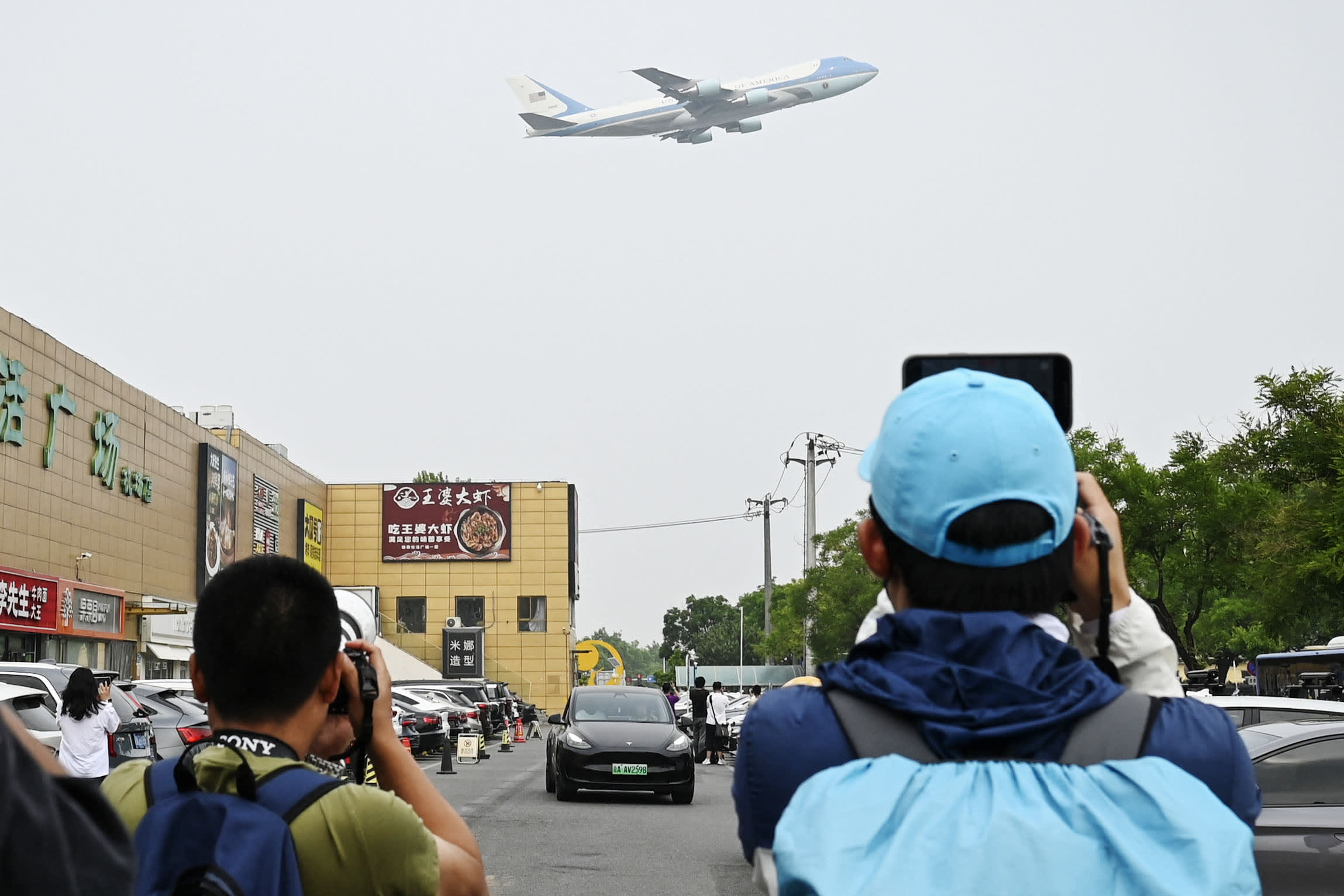 People gather to watch Air Force One, carrying US President Donald Trump, take off from Beijing Capital Airport in Beijing on May 15, 2026. 