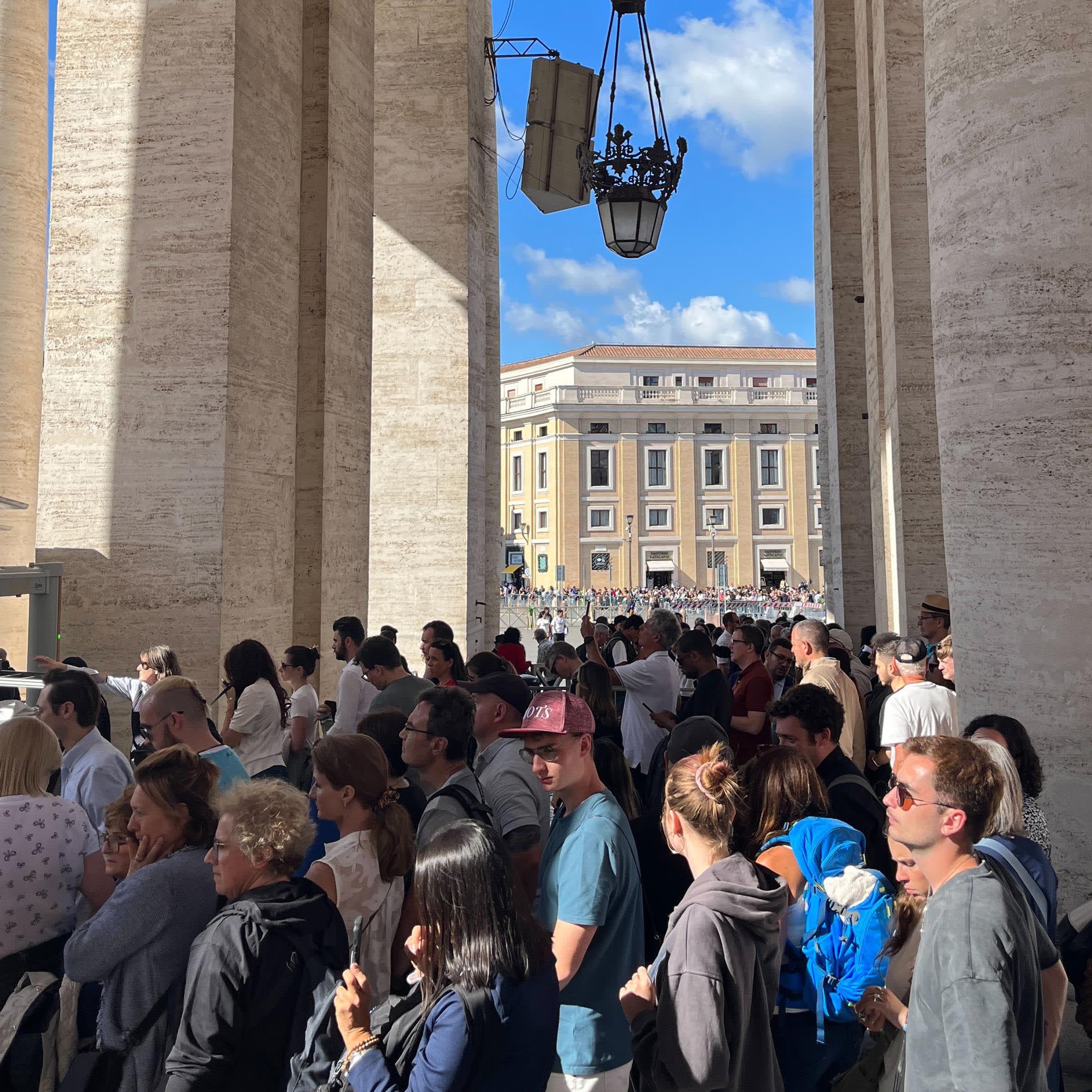 People wait in line for security screenings to enter St. Peter's Square at the Vatican on May 8, 2025.