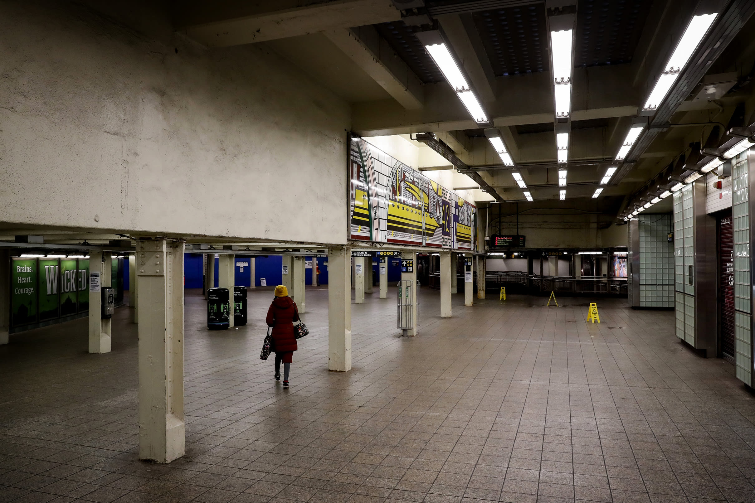 Image: A woman walks through the nearly empty Times Square subway station in New York on Thursday.