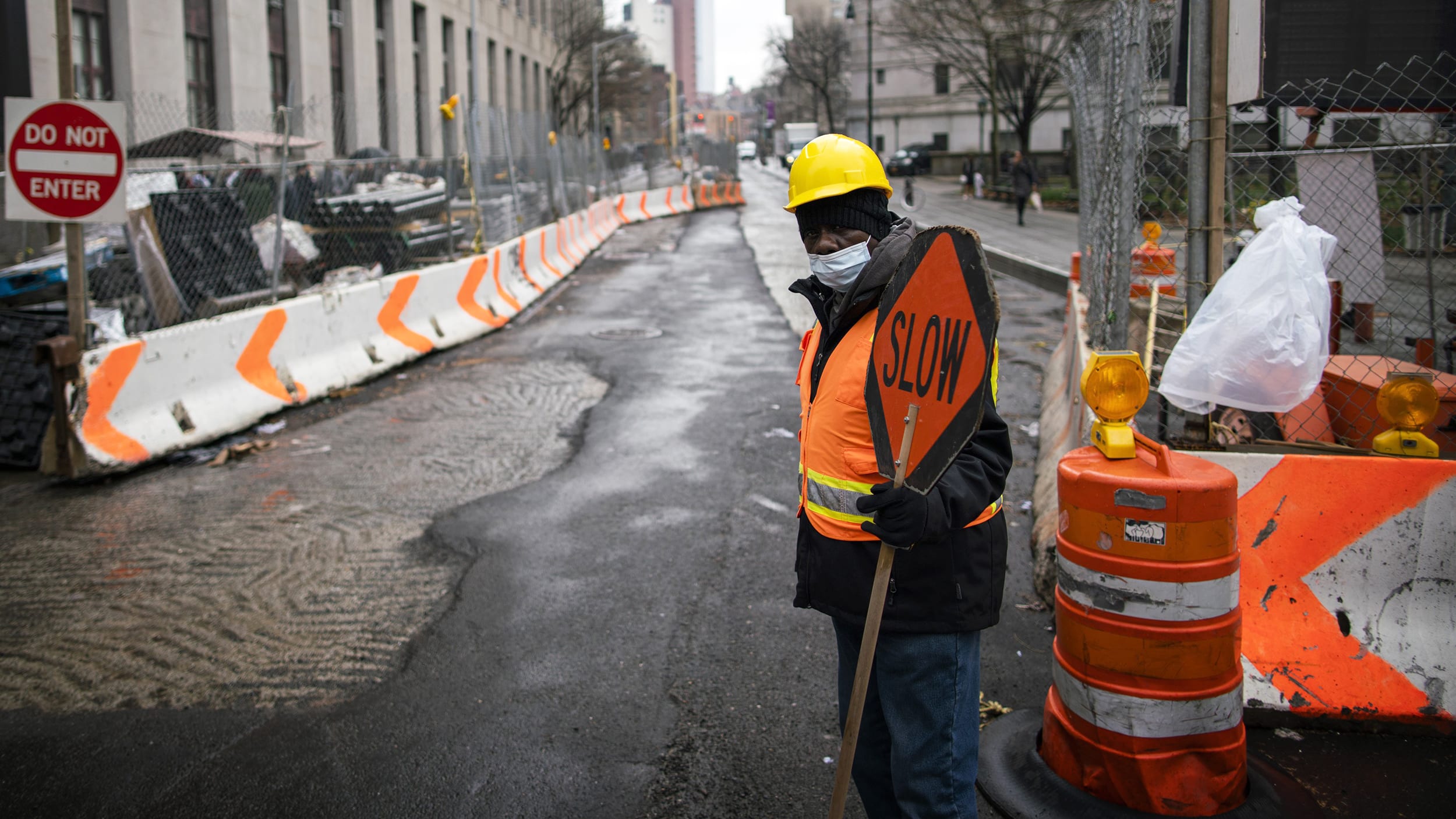 Image: A worker wearing a mask watches a road in New York on March 17, 2020.