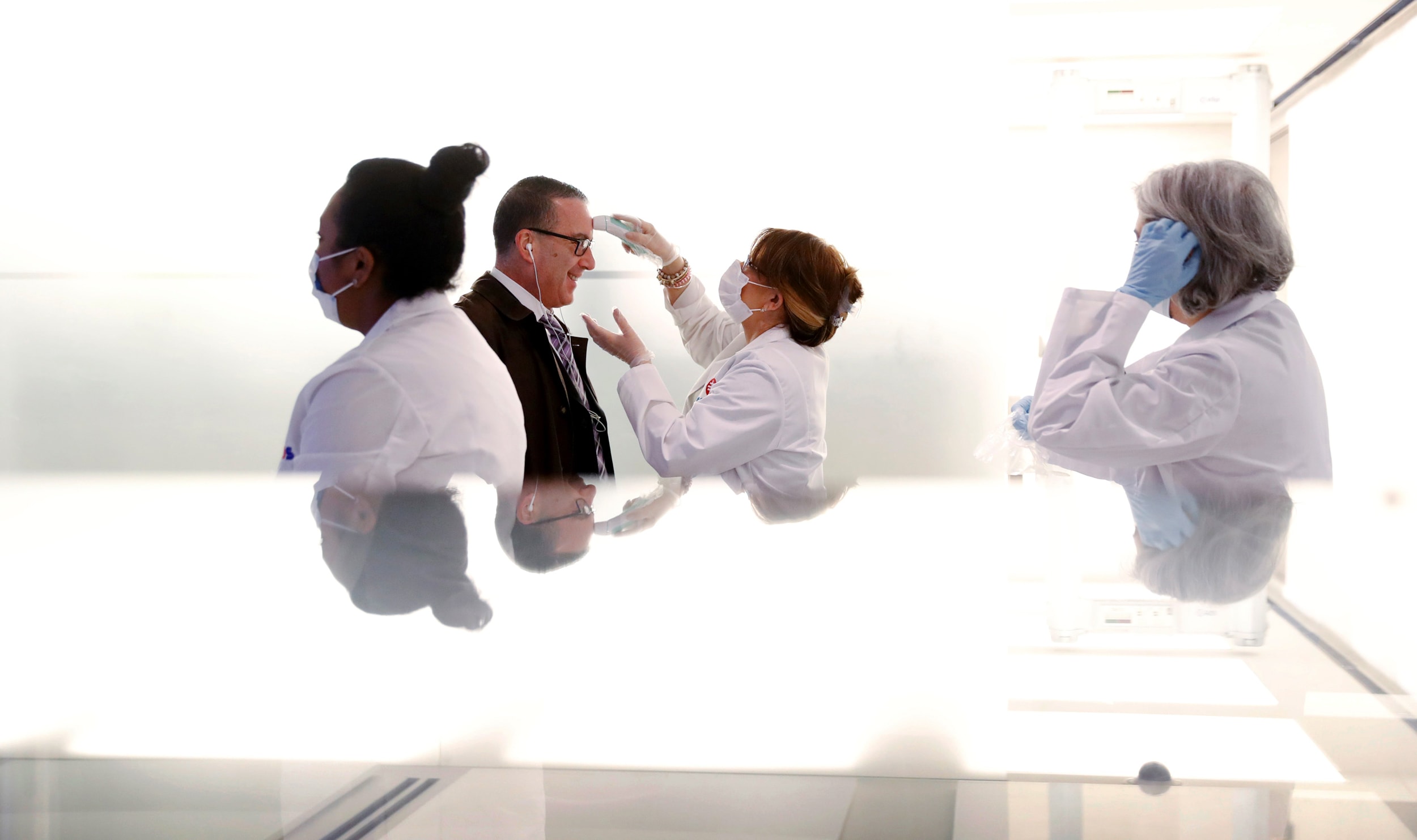 Image: Employees entering the New York Stock Exchange are screened for fever on Tuesday.