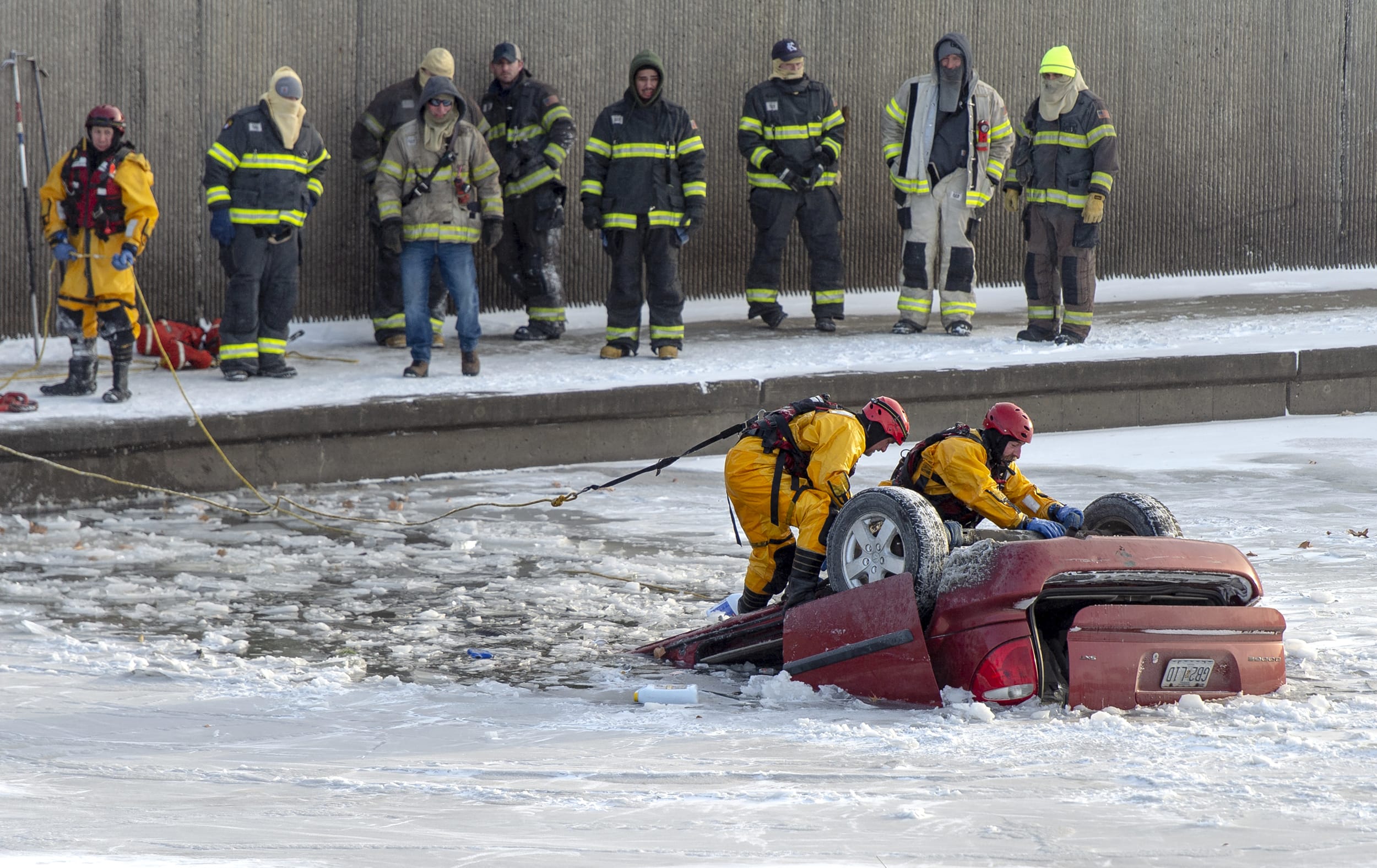 Fire department rescue workers work to recover a minivan that went into Brush Creek in Kansas City, Mo., on Dec. 22, 2022.