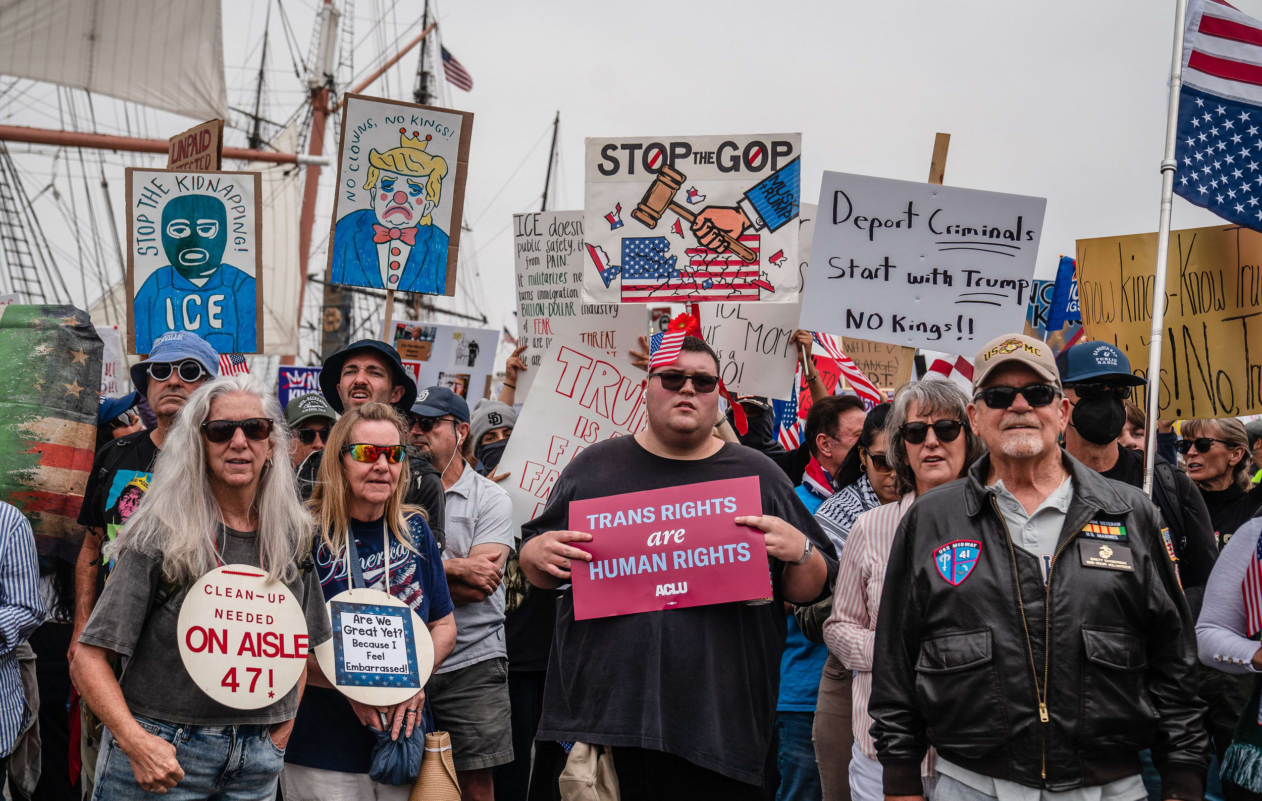 Demonstrators hold anti-Trump signs.