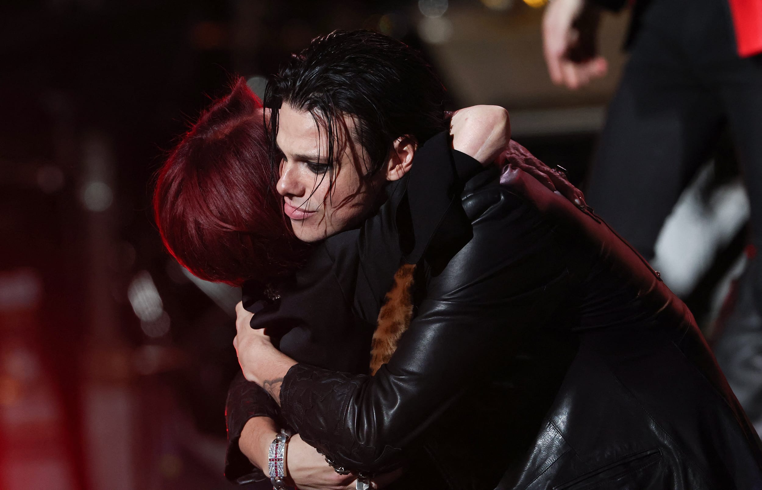 YUNGBLUD hugs Sharon Osbourne on stage. They both are wearing black.