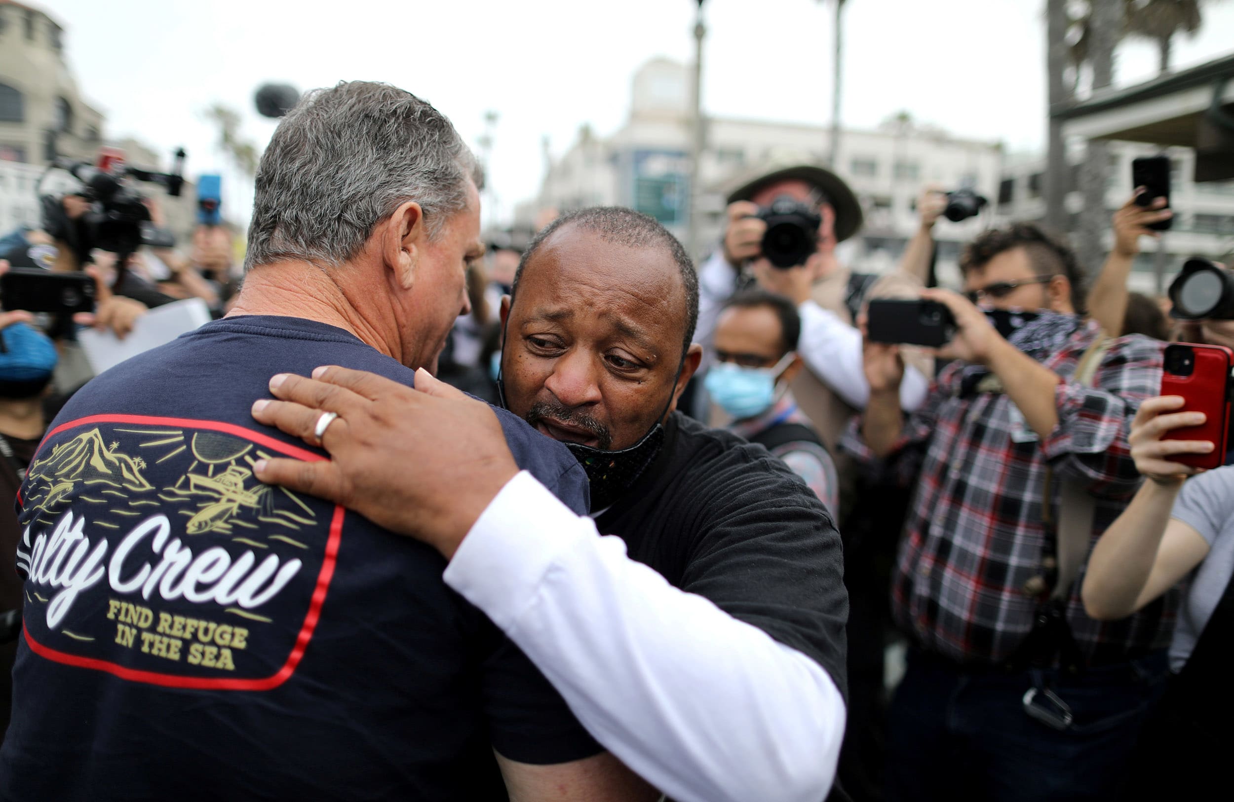 Image: Najee Ali, a Black Lives Matter activist, embraces Peter Zazzara, a former Marine and White Lives Matter activist, in Huntington Beach, Calif.