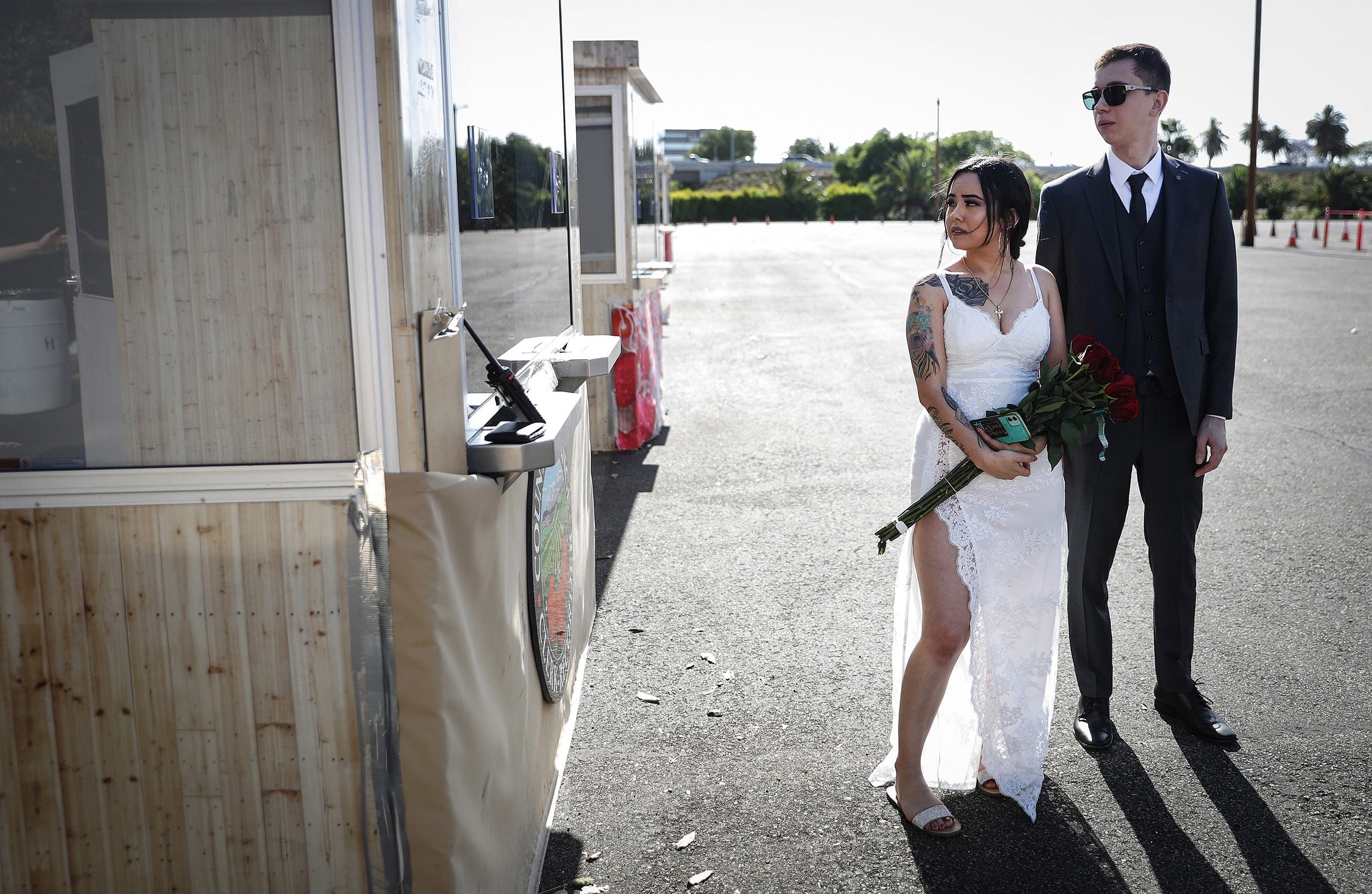 Image: A couple wait to exchange marriage vows at one of six pop-up socially distanced marriage booths in the parking lot of the Honda Center amid the coronavirus pandemic on May 19, 2020 in Anaheim, California.