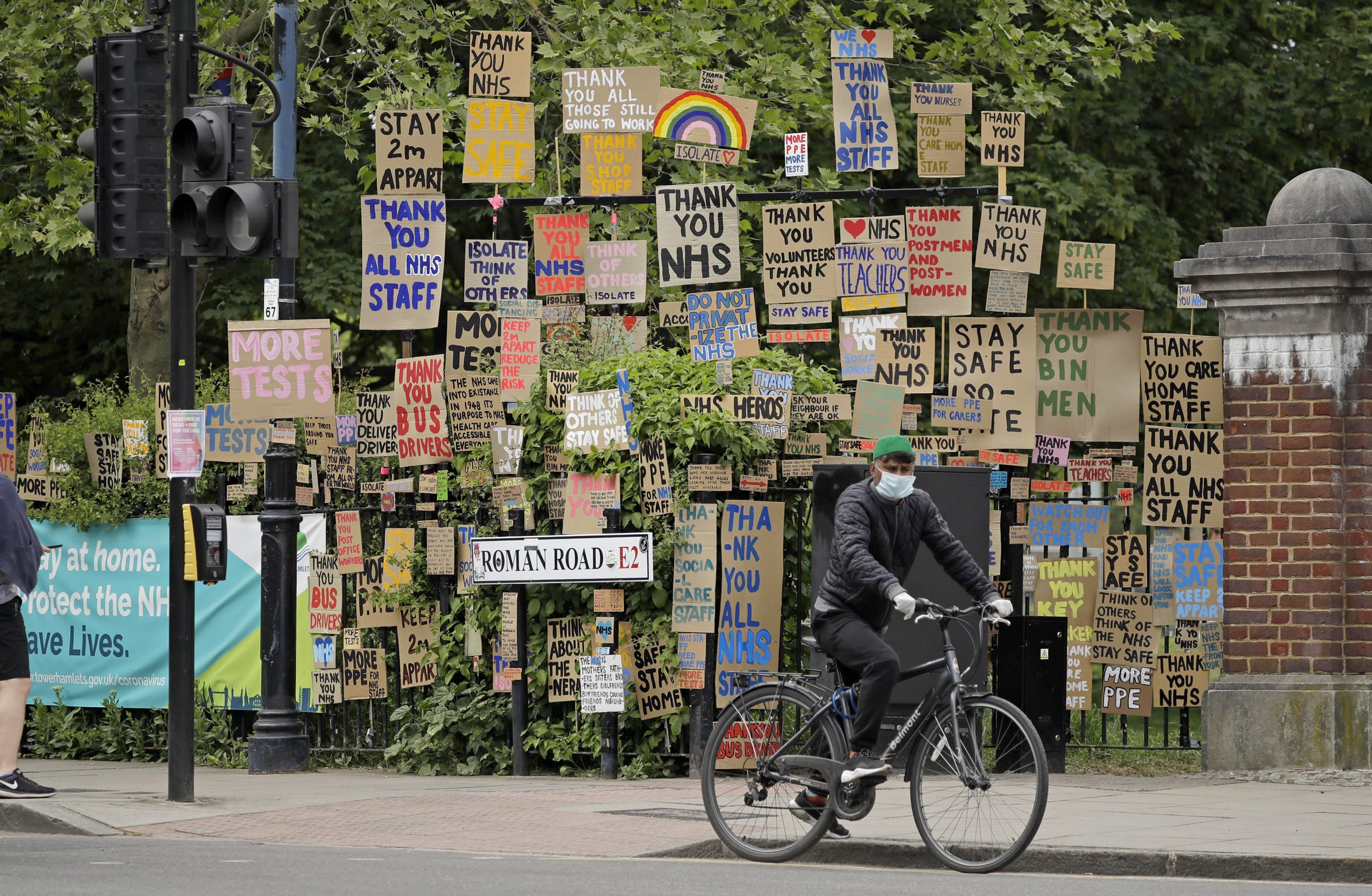 A cyclist passes signs supporting the National Health Service in a display coordinated by artist and local resident Peter Liversidge in east London, on April 27, 2020.