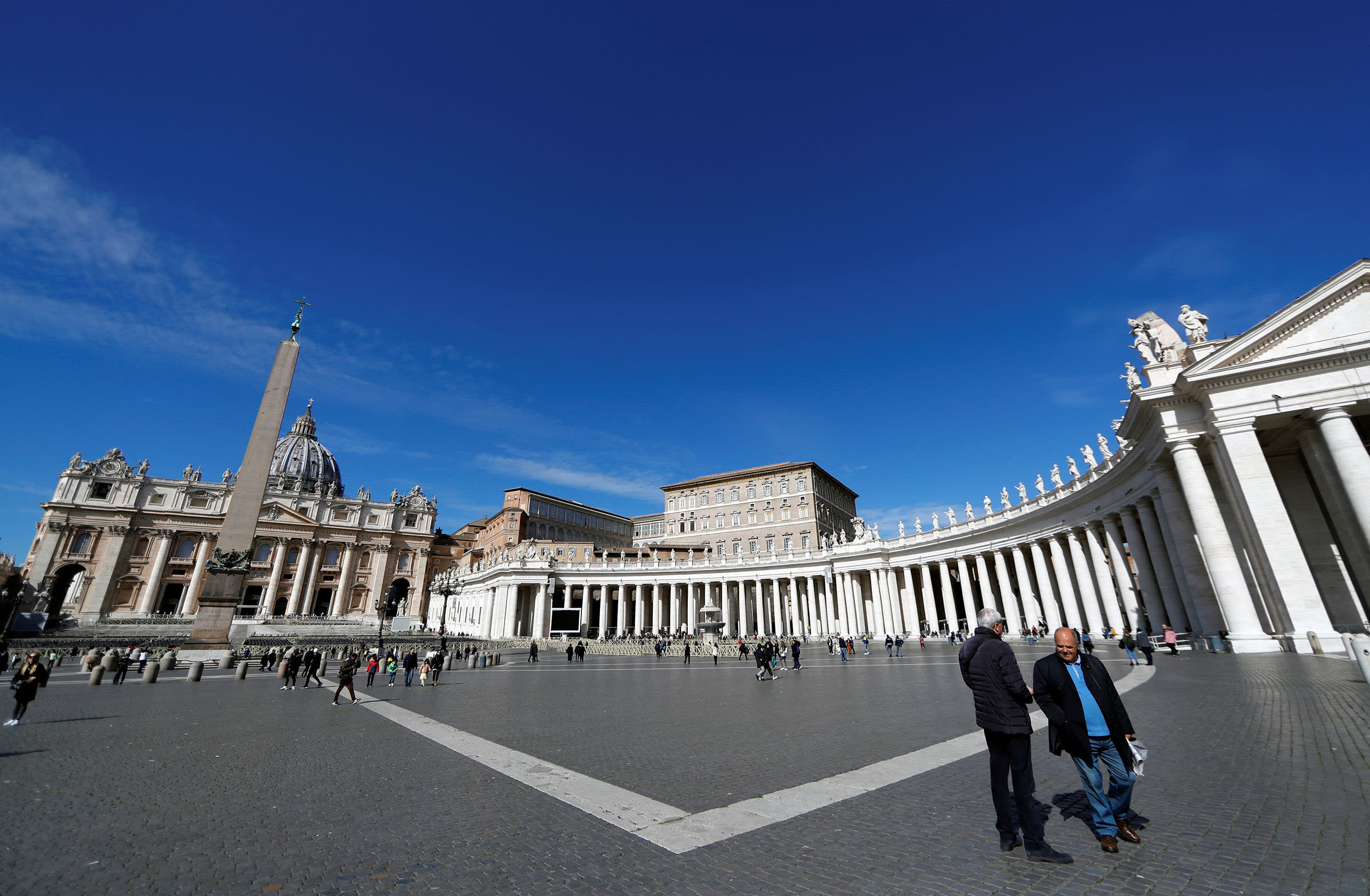 Image: People walk in Saint Peter's Square, after the Italian government decree to close schools, cinemas, and urge people to work from home and not stand closer than one metre to each other at the Vatican,