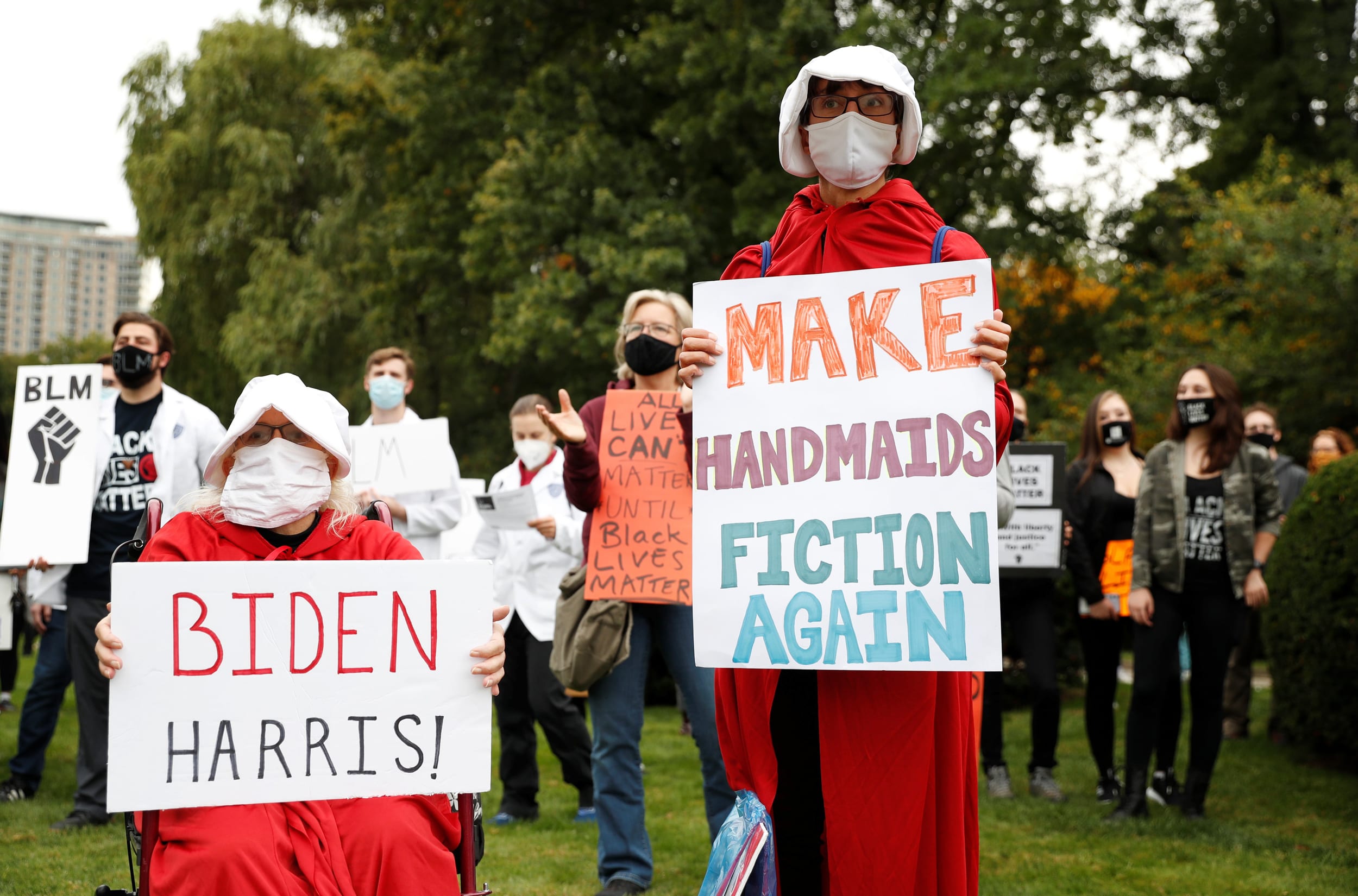 Image: Protesters dressed as handmaids hold signs before the presidential debate in Cleveland on Tuesday.