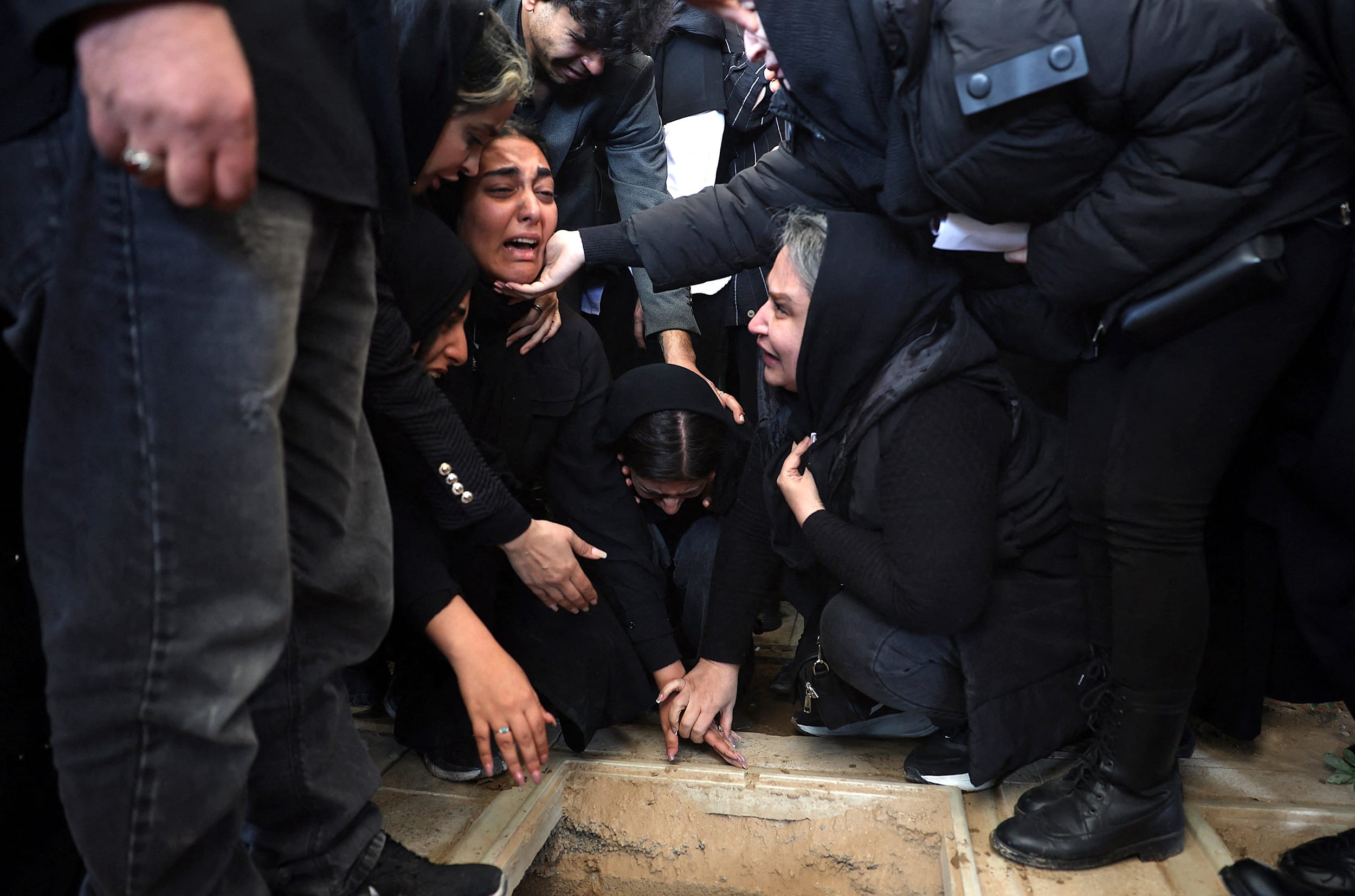 Iranian women mourn during a funeral for victims of U.S. and Israeli strikes at a cemetery in southern Tehran on March 26, 2026.