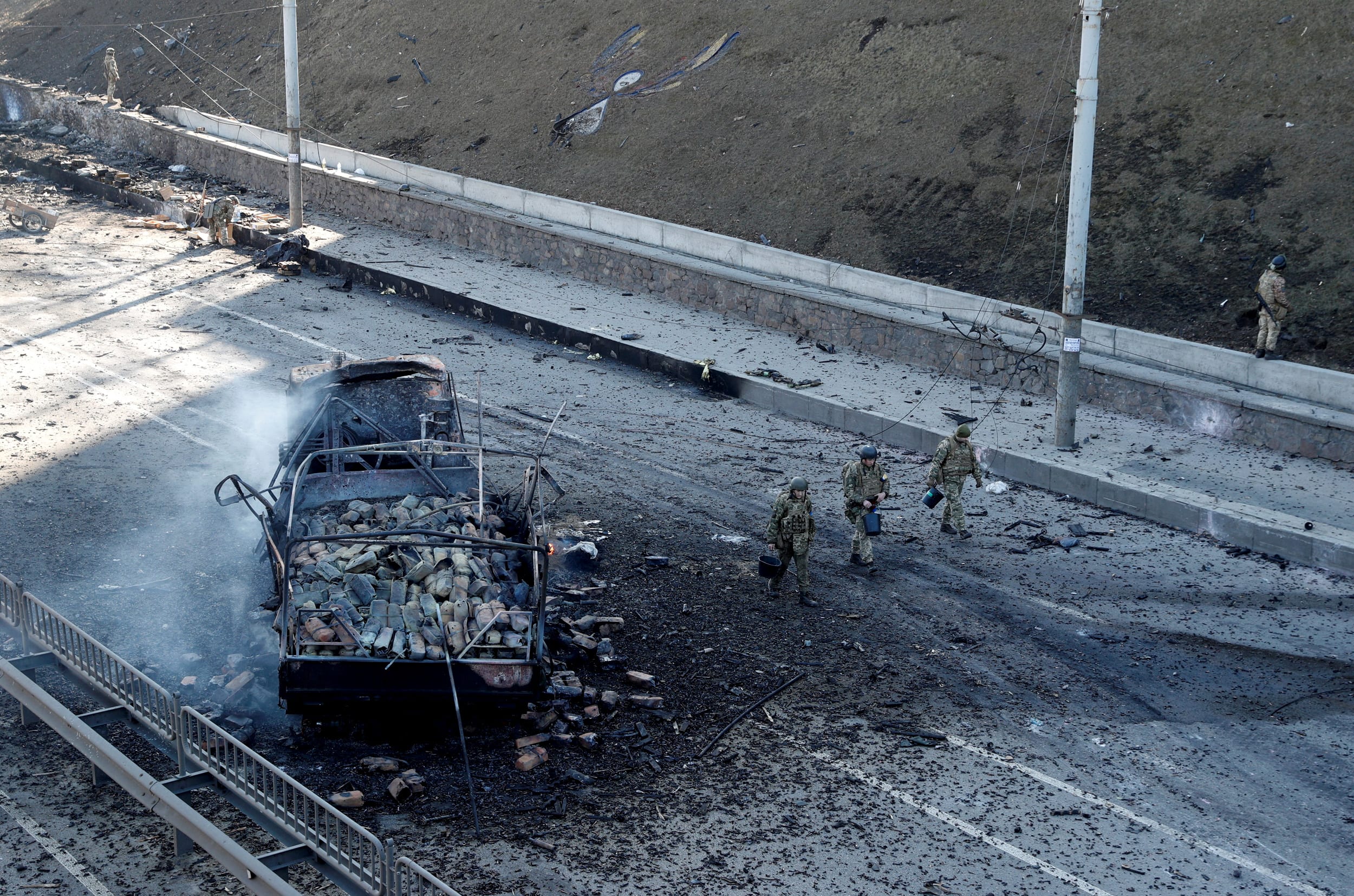 Image: Ukrainian servicemen and a damaged vehicle after fighting with Russian troops in Kyiv on Feb. 26, 2022.