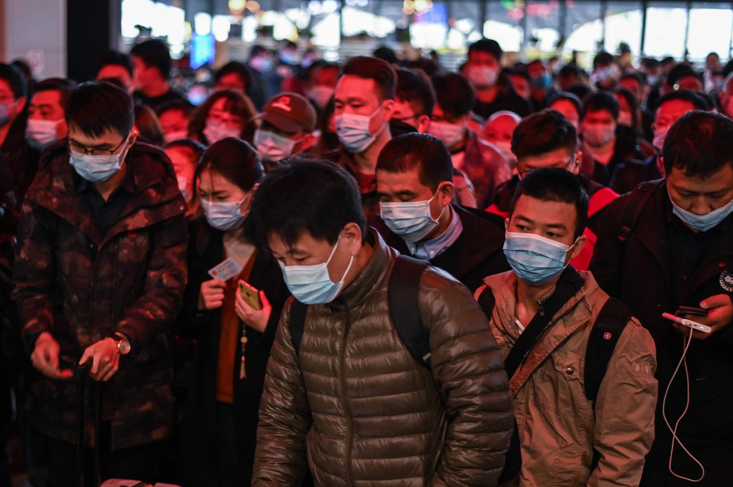 Image: Passengers wearing face masks as a preventive measure against the Covid-19 coronavirus walk to their train at Wuhan railway station in Wuhan, China's central Hubei province