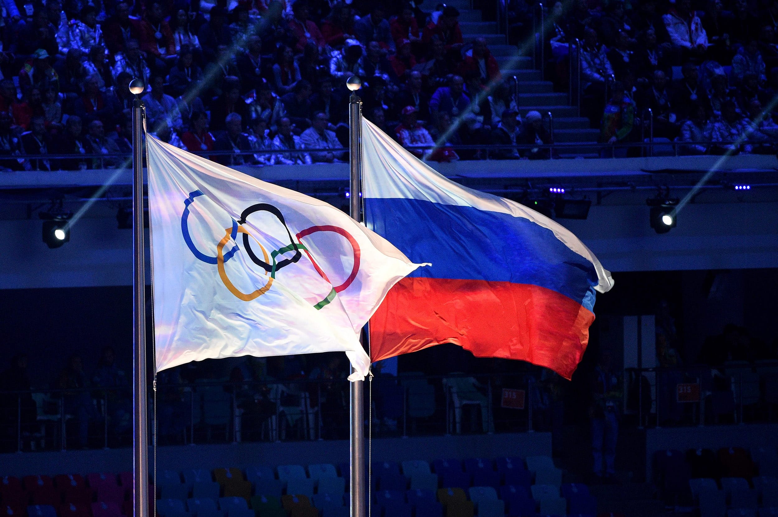 Image: The Olympic flag and the Russian flag flying during the Closing Ceremony of the Sochi Winter Olympics at the Fisht Olympic Stadium in Sochi.