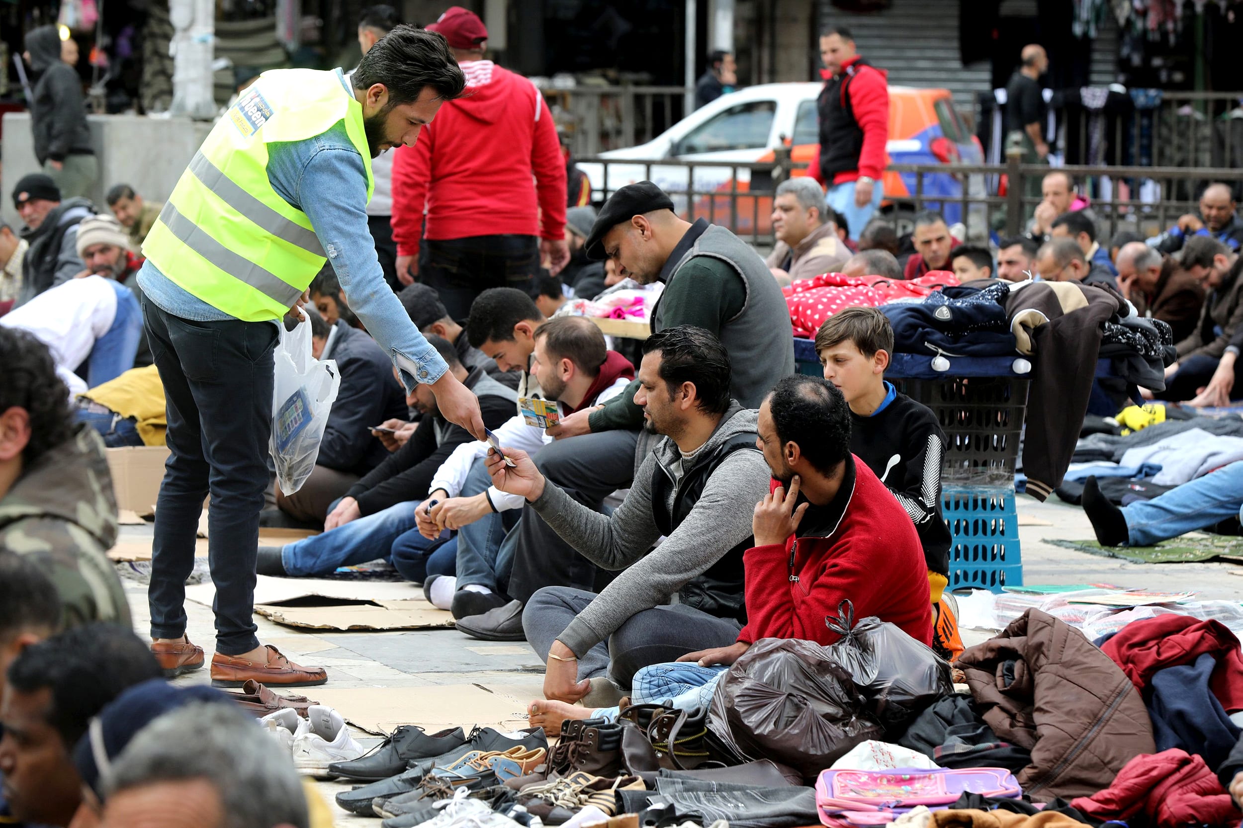 Image: A staff member from sanitizing company distributes hand sanitizer for free for worshippers during Friday prayers outside al Husseini mosque in downtown Amman