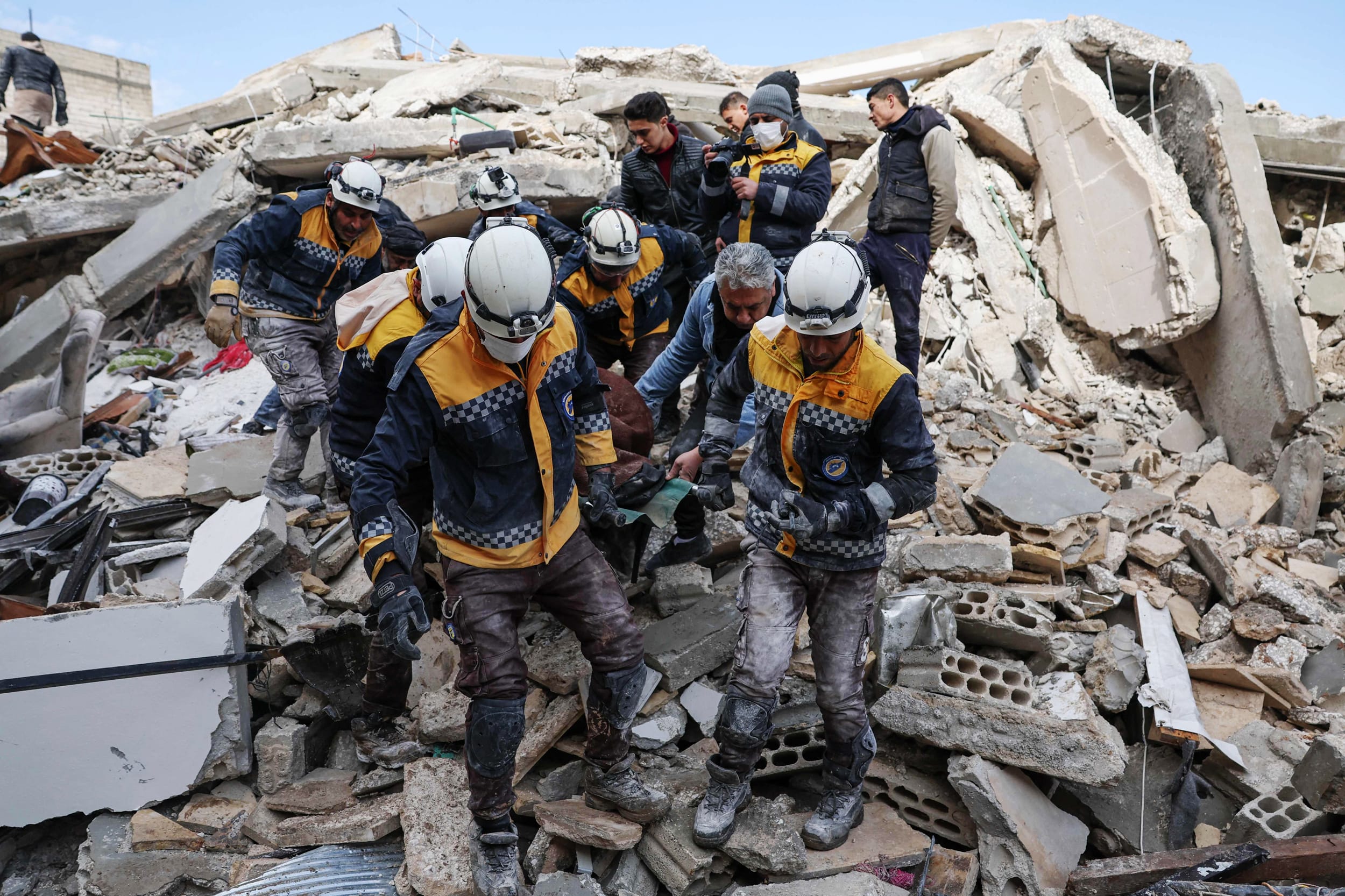 Members of the Syrian civil defense, known as the White Helmets, transport a casualty from the rubble of buildings in Azmarin in Syria's rebel-held northwestern Idlib province on Feb. 7, 2023.