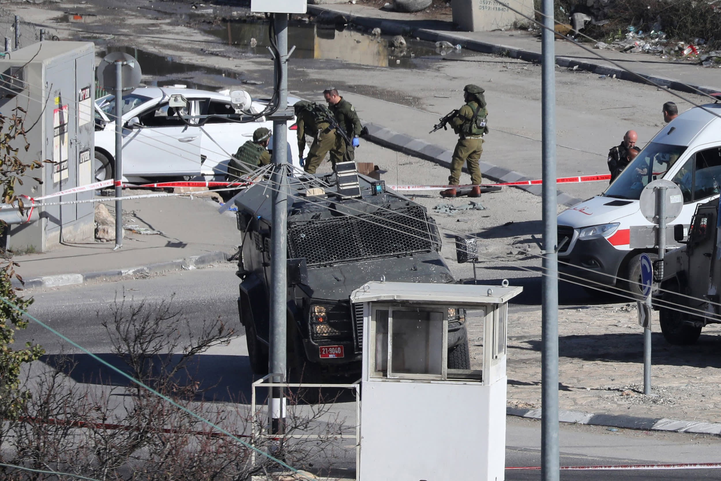 Israeli forces cordon off an area after a Palestinian driver was shot by Israeli soldiers as he reportedly attempted a ramming attack at the Beit Einun junction, north of the West Bank city of Hebron on Dec. 20, 2023.