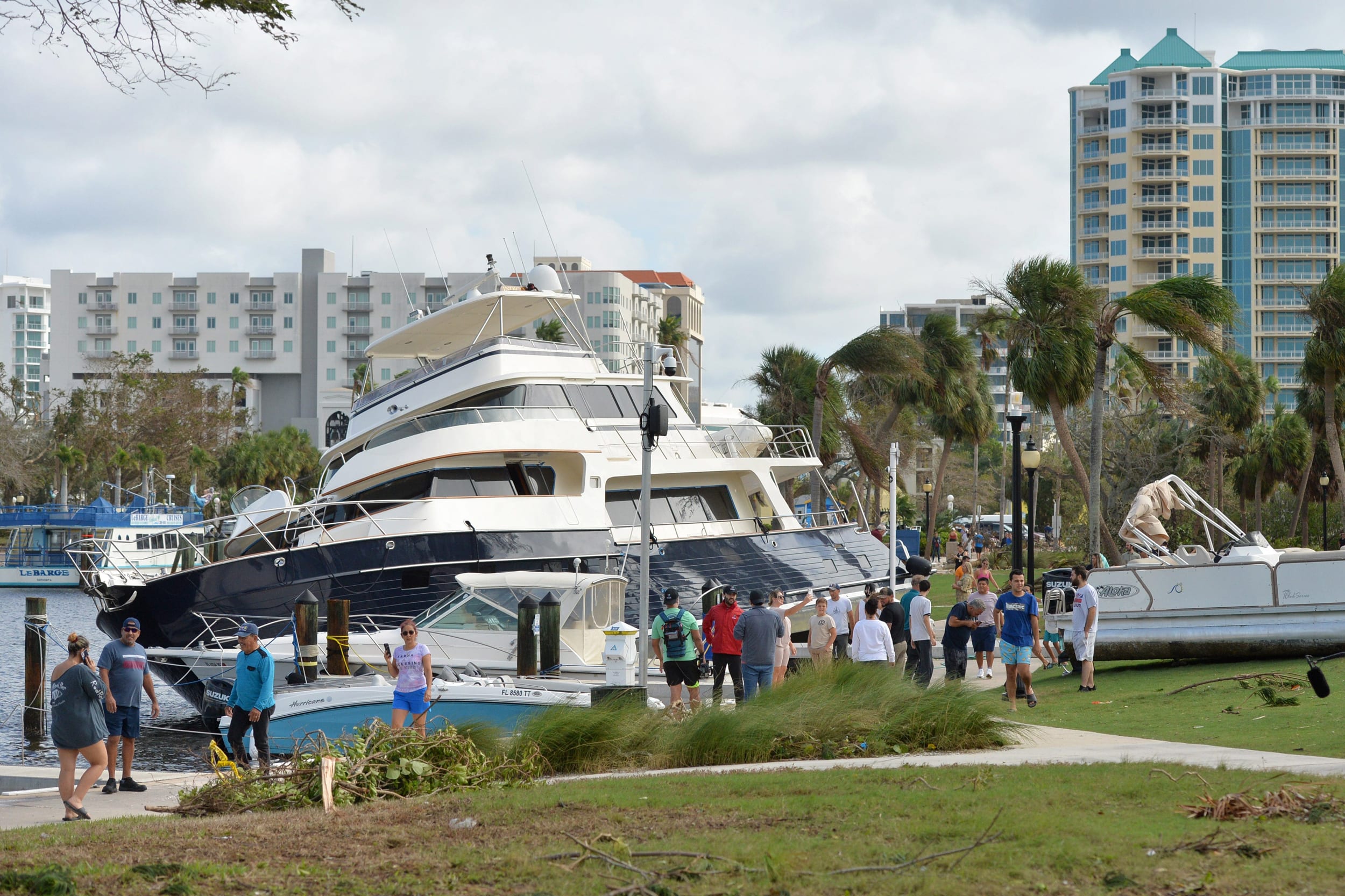 Yacht and a pontoon boat washed up on shore