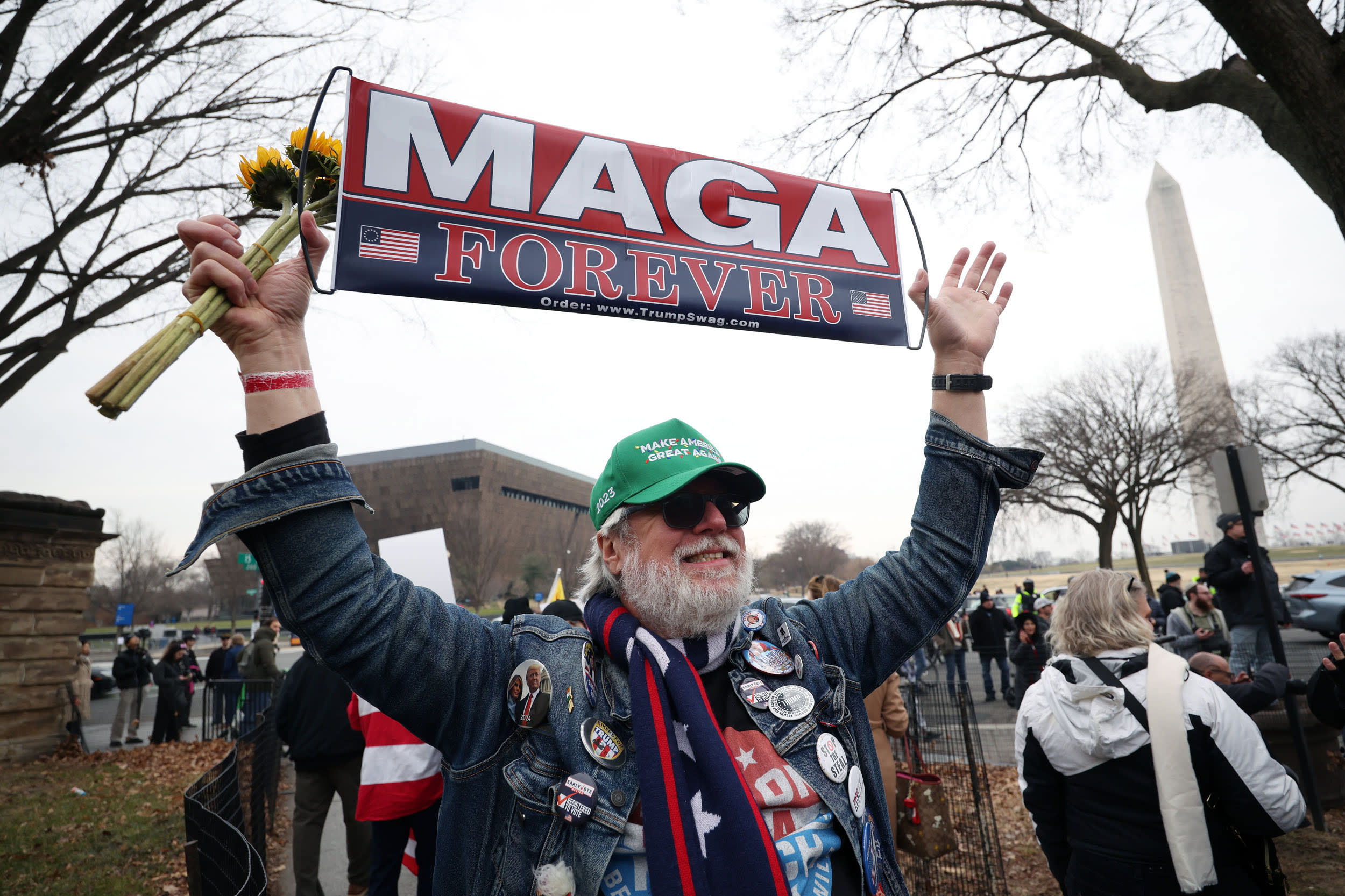 Edward Young holds a "MAGA FOREVER" sign during a January 6th memorial march marking five years since the attack.