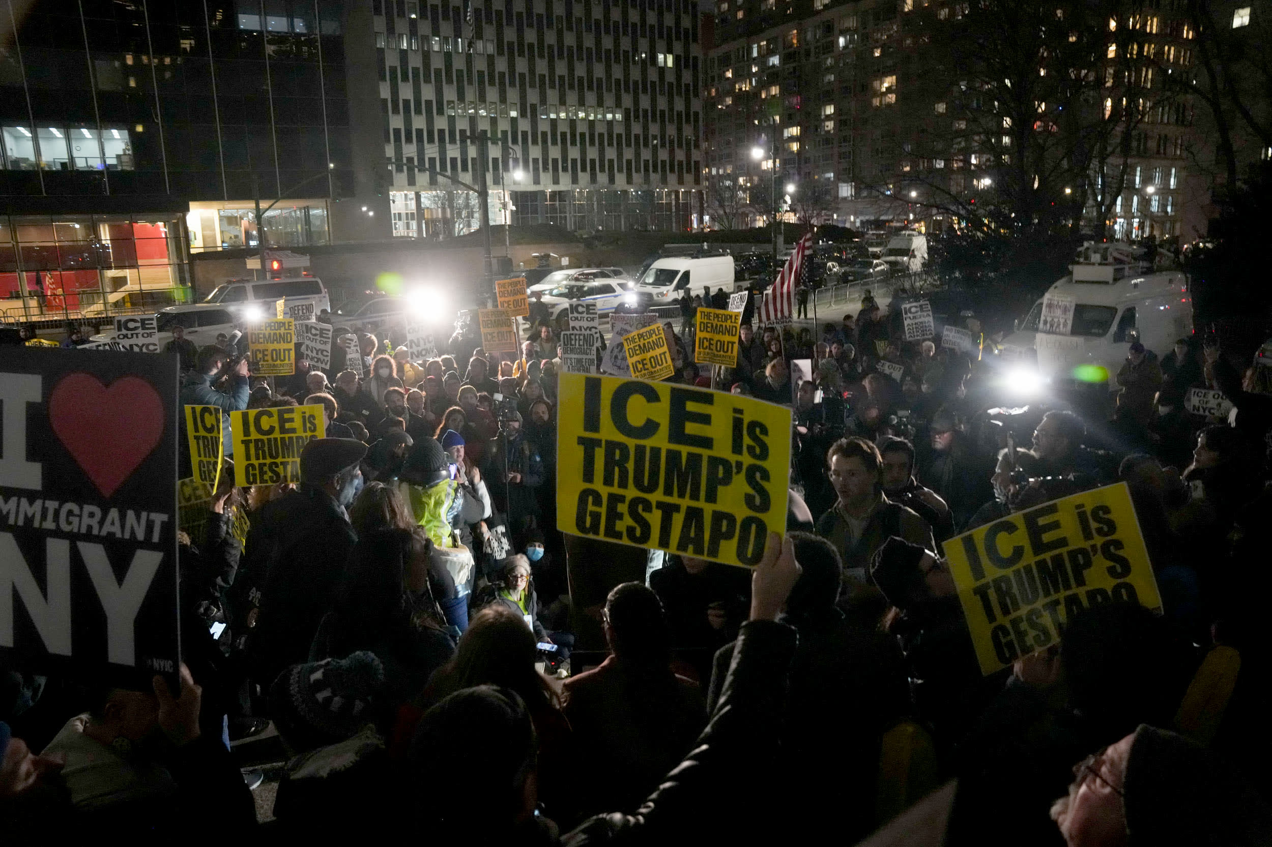 Protesters hold signs that read "ICE is Trump's Gestapo" 
