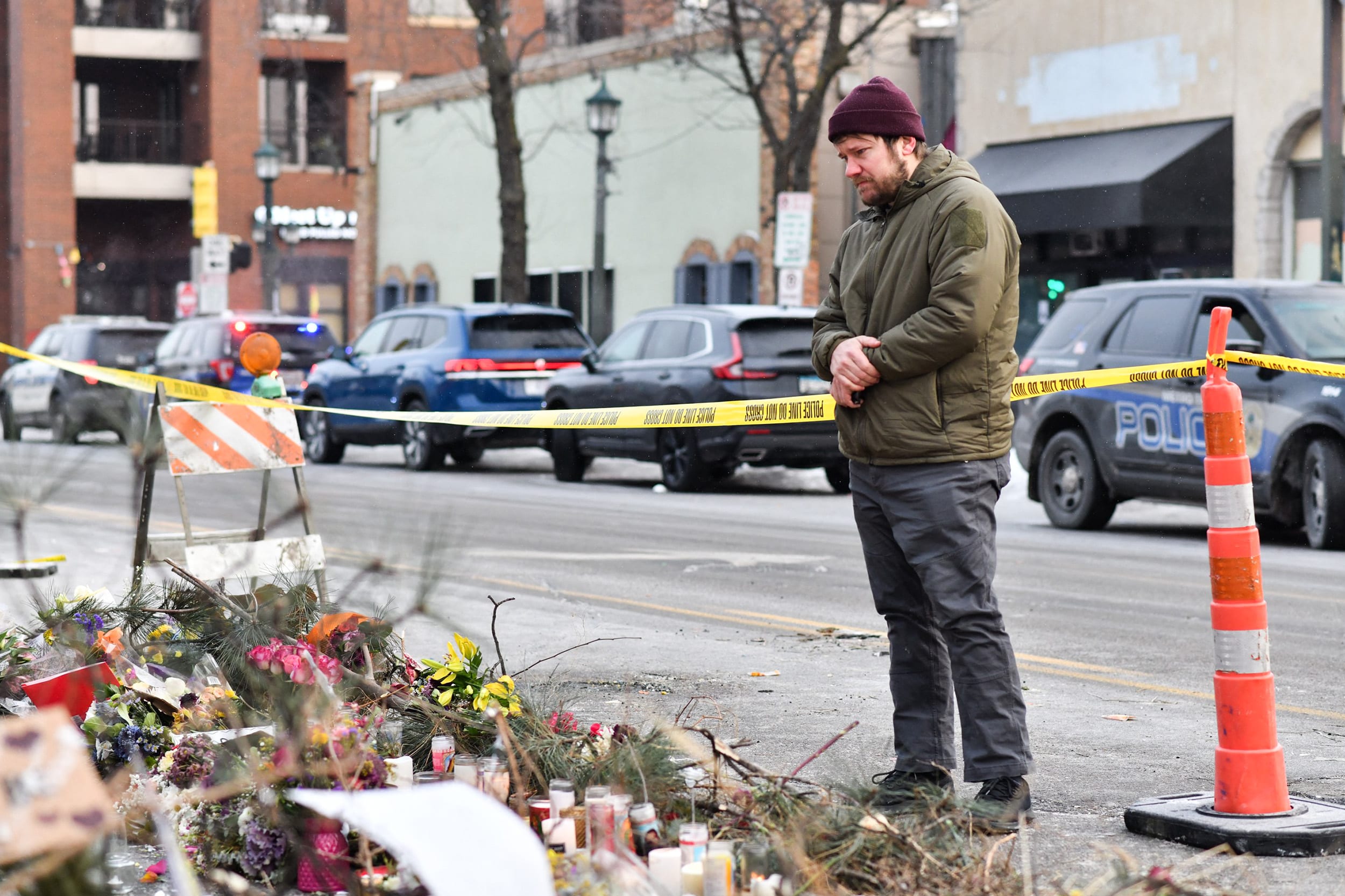 A mourner visits a memorial for Alex Pretti at the location he was shot dead in Minneapolis, MN.