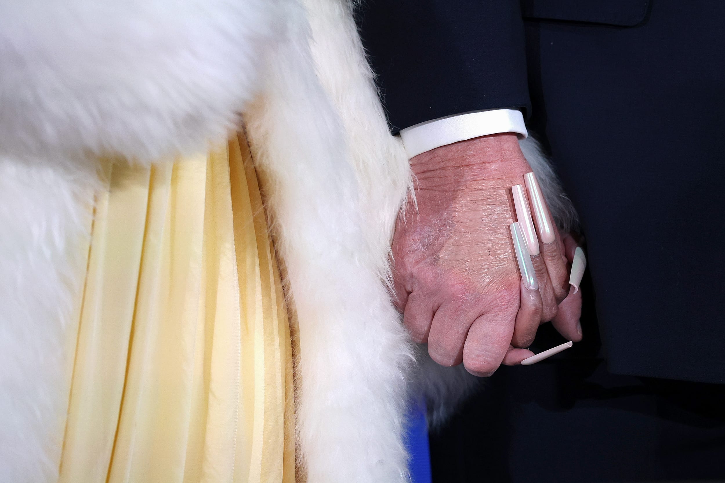 A close-up view of Nicki Minaj holding Donald Trump's hand.