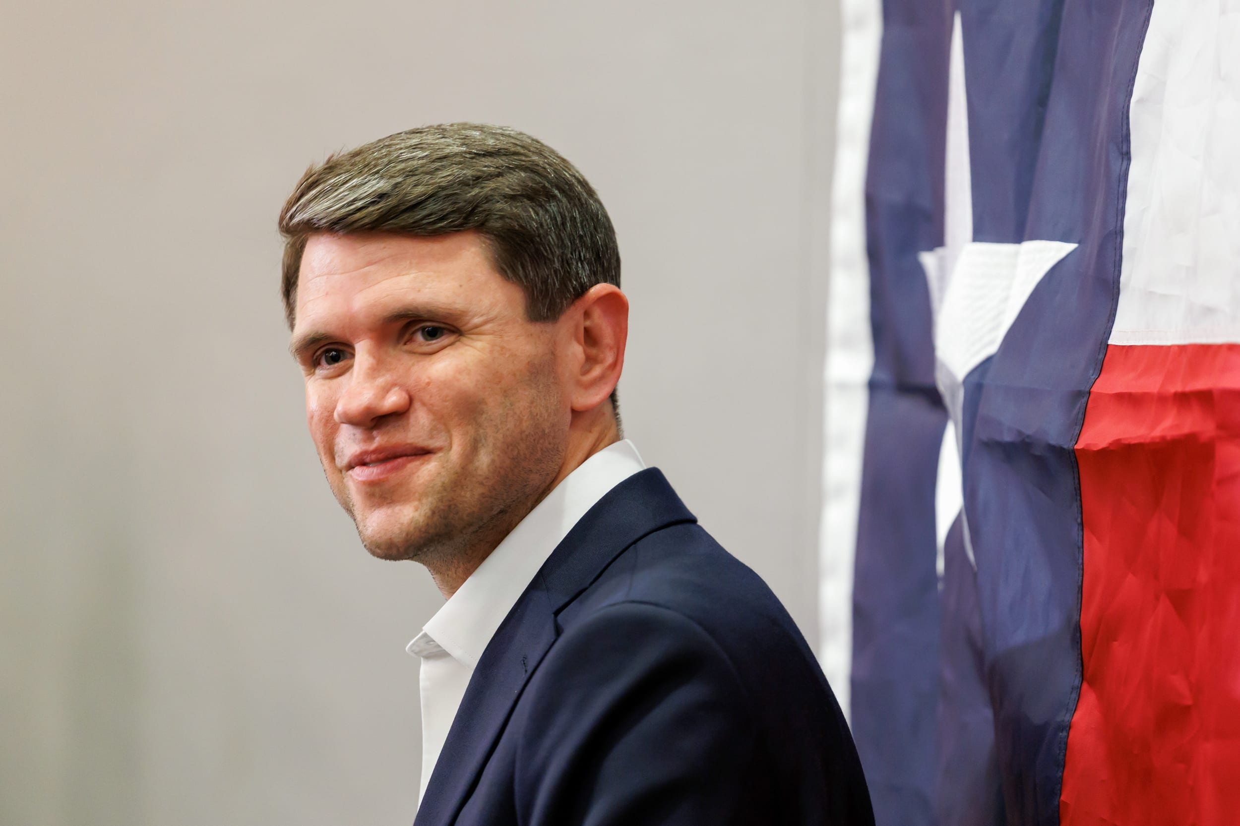 State Representative James Talarico standing next to Texas' flag