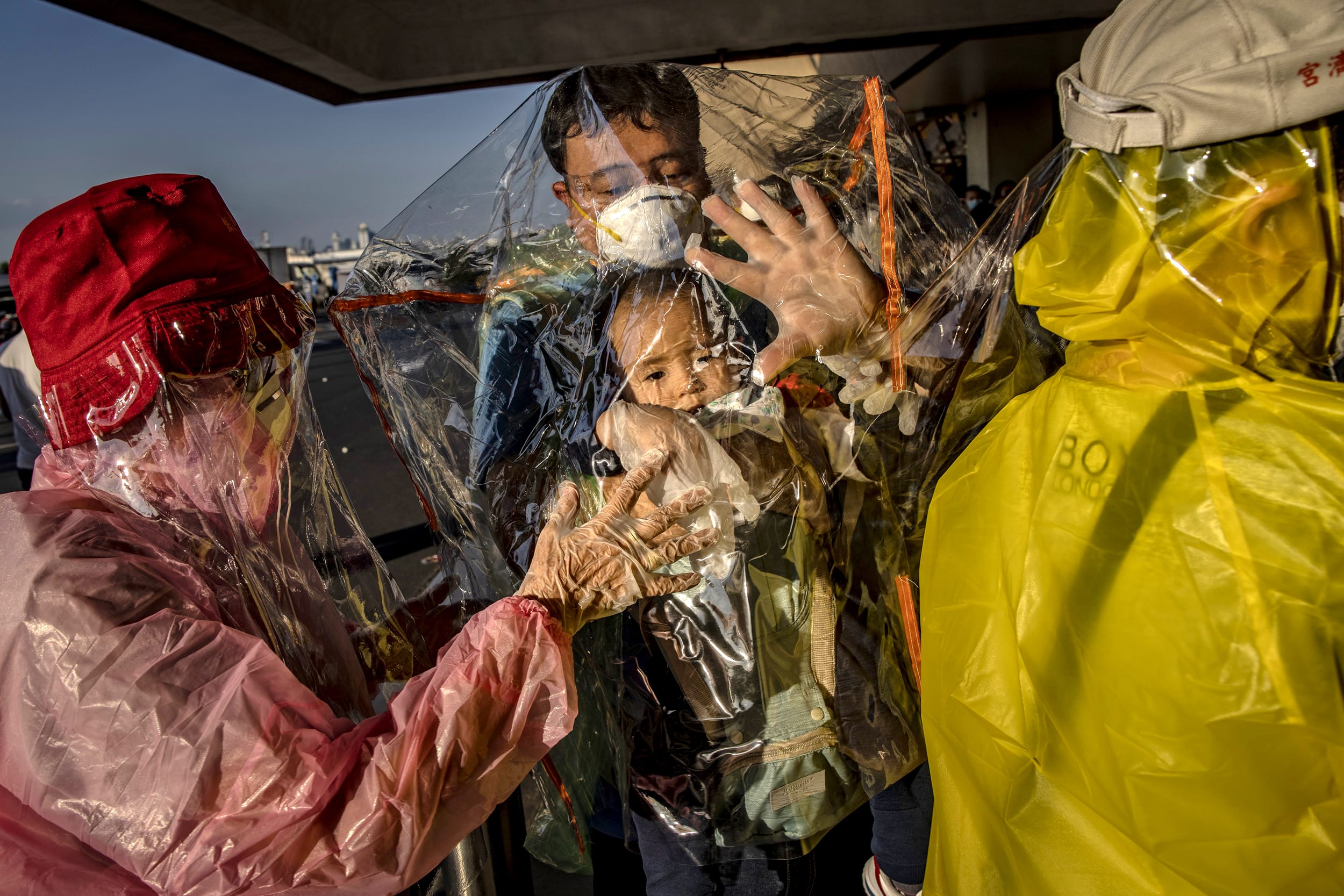 Image: Travelers wearing raincoats, plastic covers and masks wait for a flight at Ninoy Aquino International Airport in Manila, Philippines, on March 18, 2020.