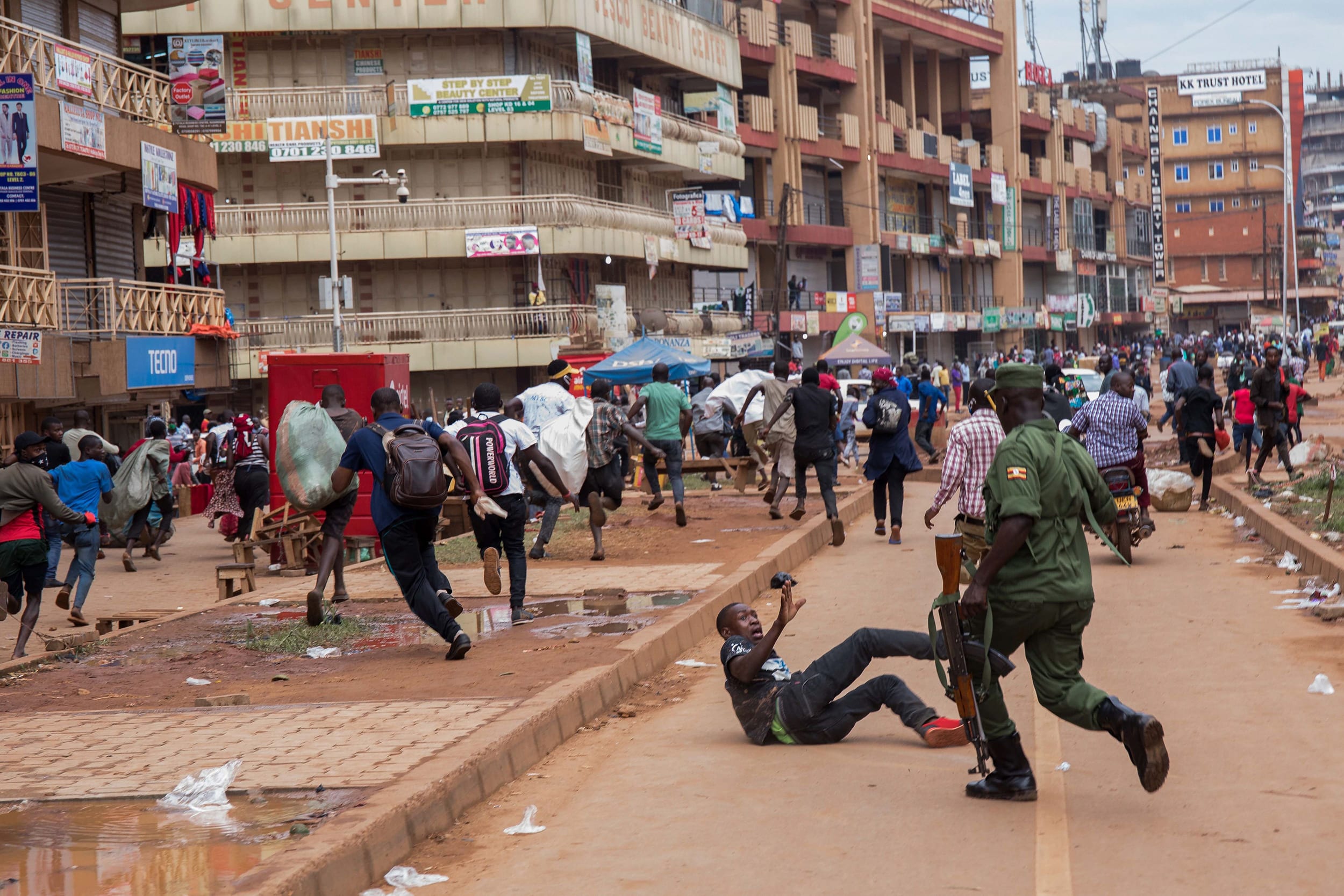 Image: A police officer chases street vendors in Kampala, Uganda,